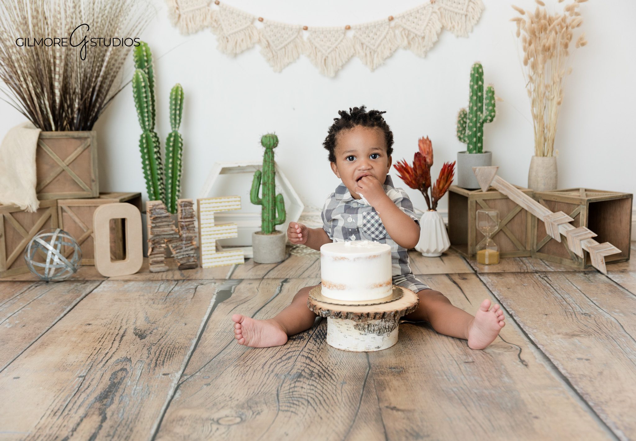 Gilmore Studios baby milestone portrait with soft garden background
Newport Beach first birthday photos with baby in plaid romper