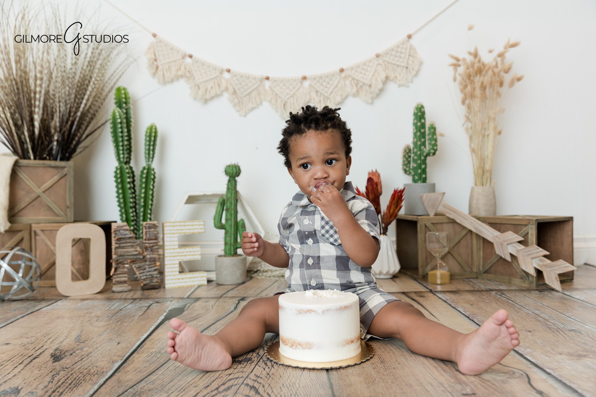 Baby boy standing in boho first birthday setup
Newport Beach boho cake smash photos with rustic decor