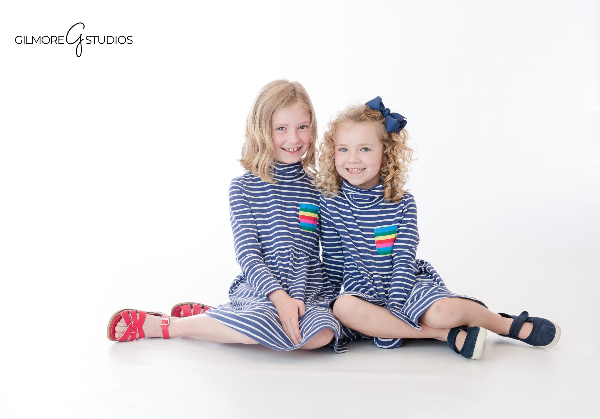 Clean and timeless children’s studio portraits by Gilmore Studios
Two young sisters smiling during white studio photography session