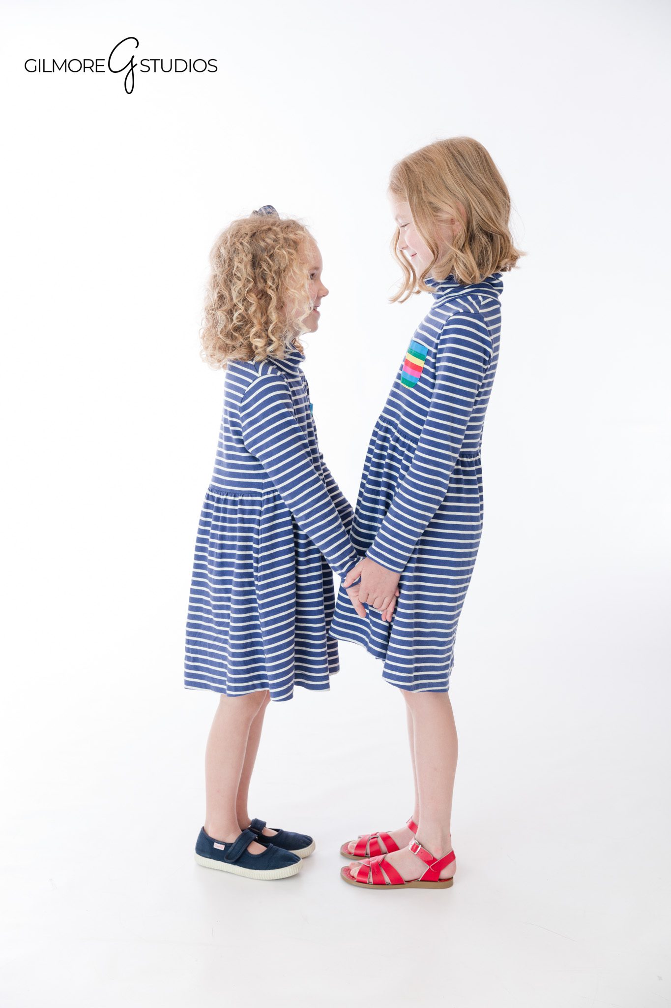 Newport Beach studio portraits for siblings on a clean white backdrop
Sisters sitting together during a white studio portrait session