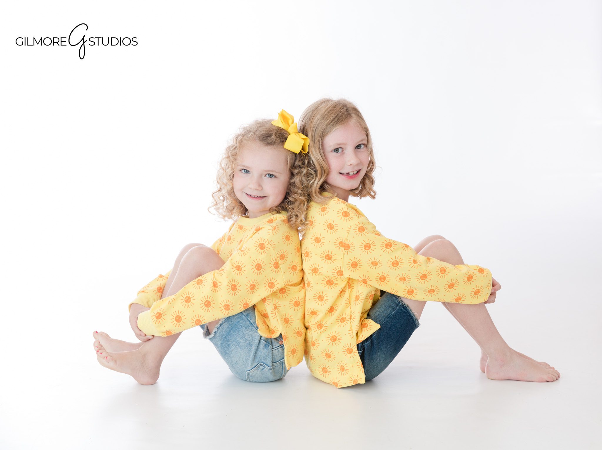 White background sibling portrait with blue striped dresses
Newport Beach children’s photographer capturing sweet sister portraits