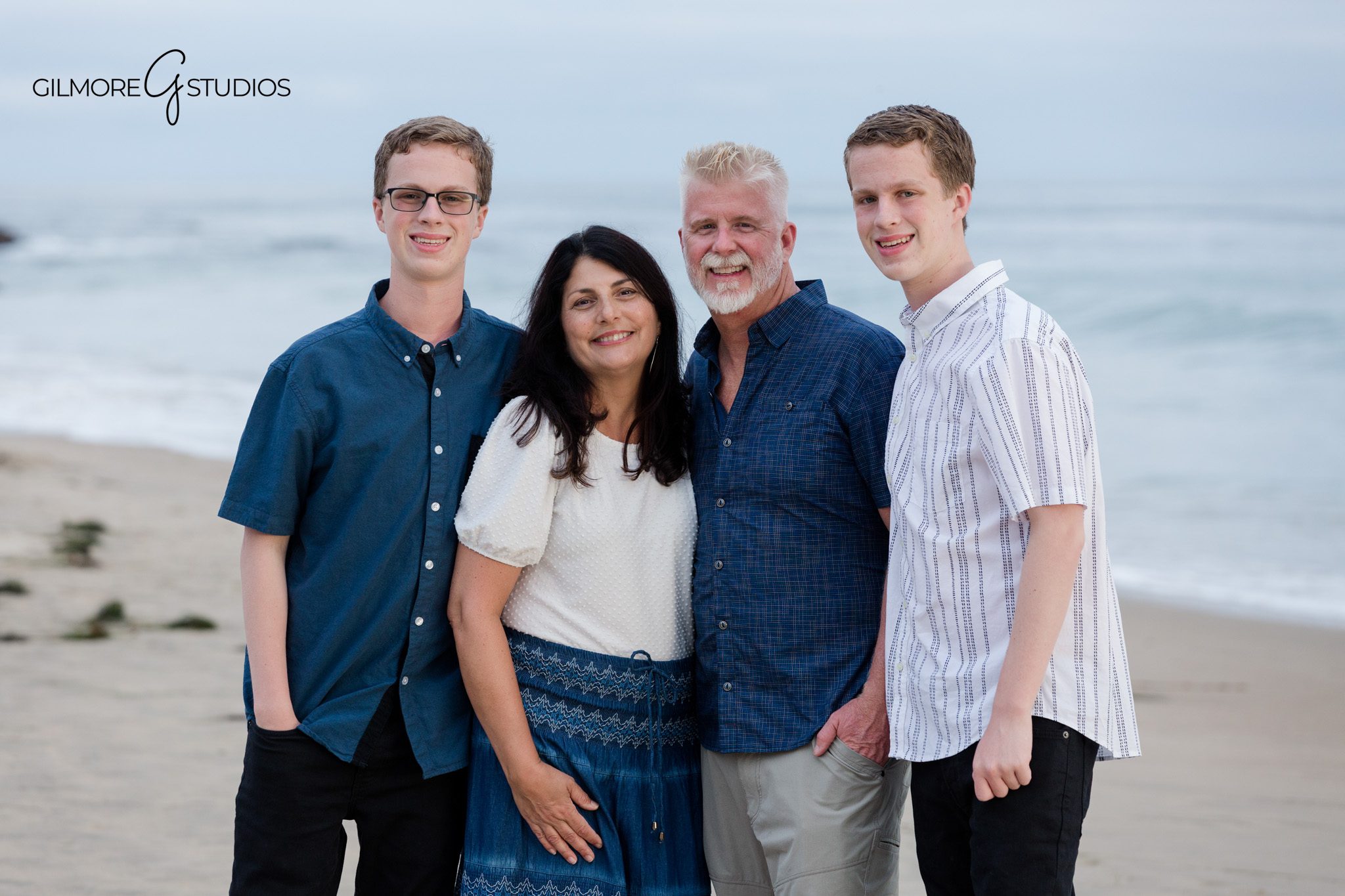 Senior portrait at Crystal Cove with soft gray sky and ocean view
Teen boy senior photo on Newport Beach coastline