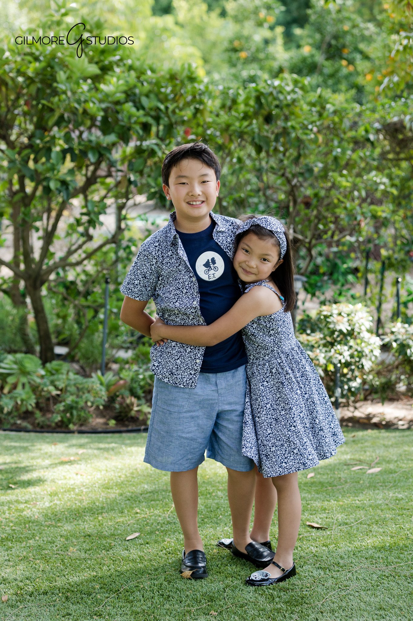 Newport Beach sibling photography session with children in coordinated blue outfits
Brother and sister portrait in a lush Newport Beach garden