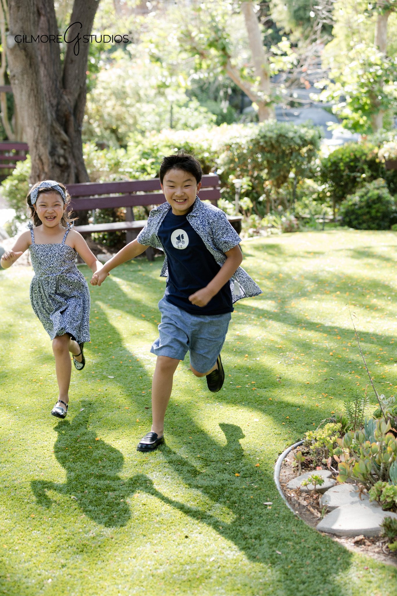 Brother and sister running hand in hand during outdoor portraits
Natural sibling photography with garden setting and candid expressions