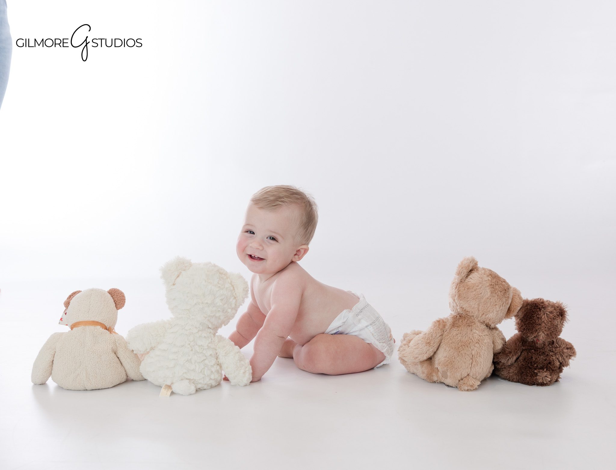 Baby boy sitting in light blue outfit for teddy bear cake smash
Queen Creek cake smash session with blue sky and teddy bear backdrop
