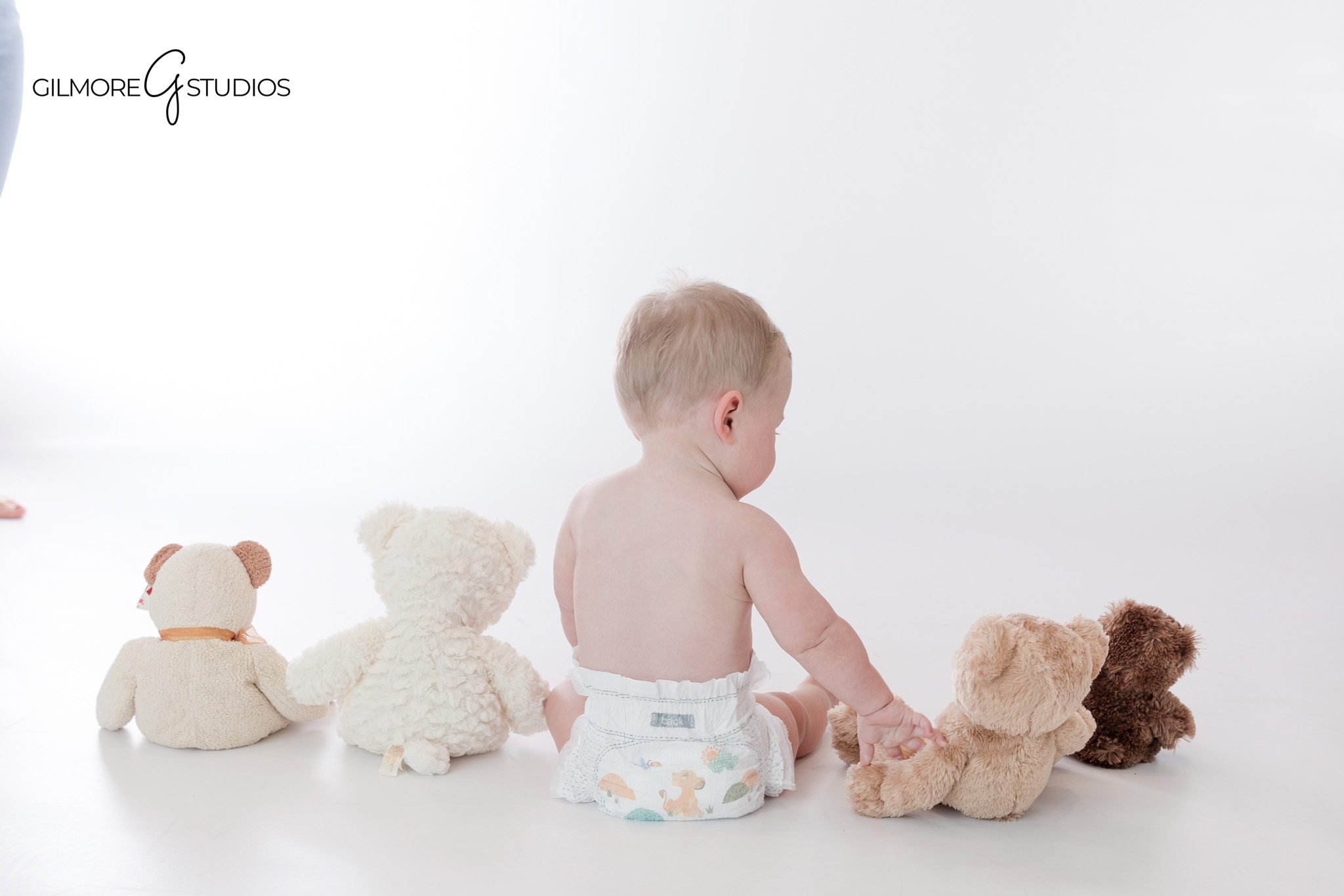 Neutral teddy bear baby photos for one year old milestone session
Queen Creek studio baby photography with white background and teddy bears