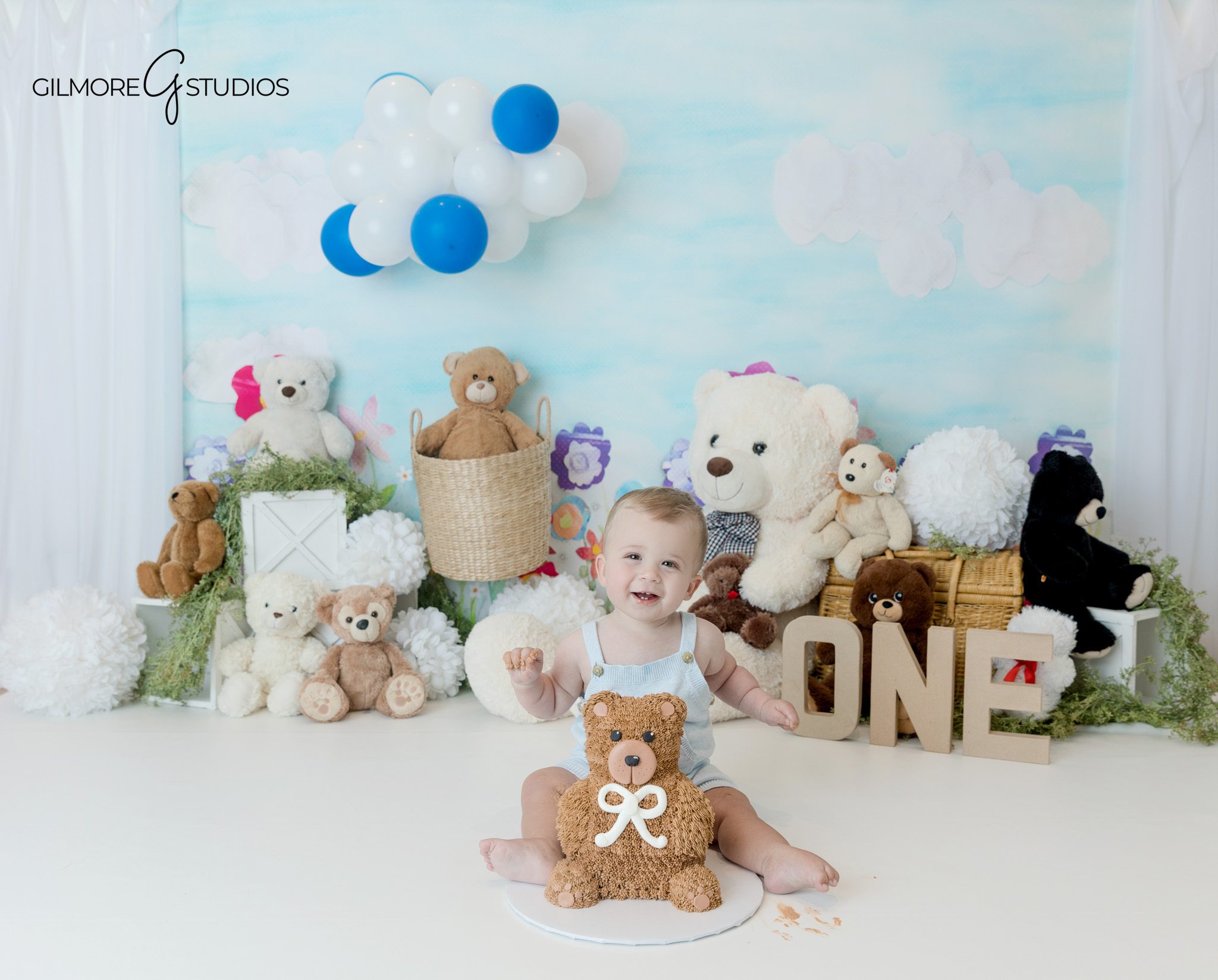Baby boy sitting with teddy bears in bright Queen Creek portrait studio
Classic teddy bear theme for first birthday cake smash photos