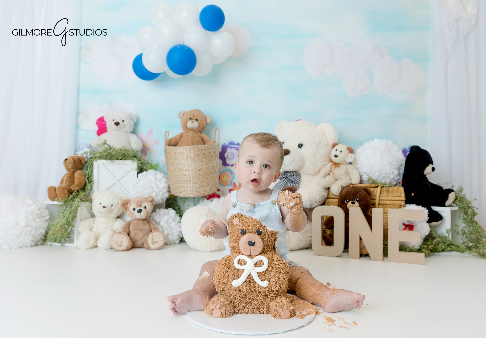 Teddy bear themed baby milestone photos by Gilmore Studios
One year old boy smiling with stuffed animals in Queen Creek studio