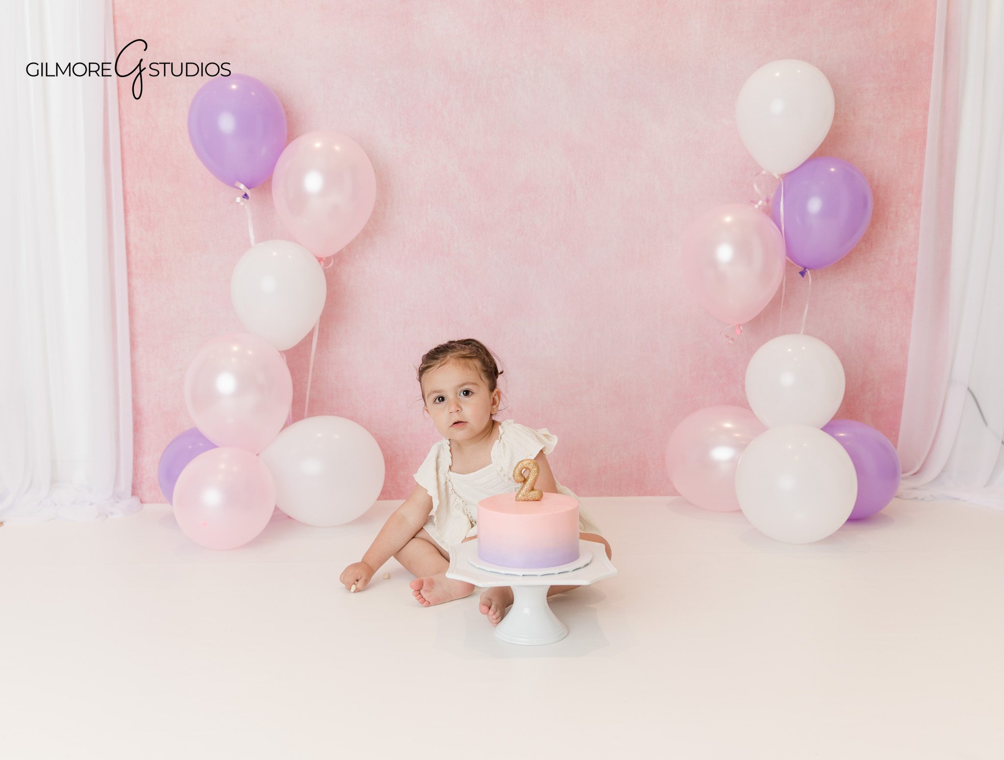 Toddler girl in pink tulle dress with mom during birthday photos
Studio milestone session with mother and toddler before cake smash