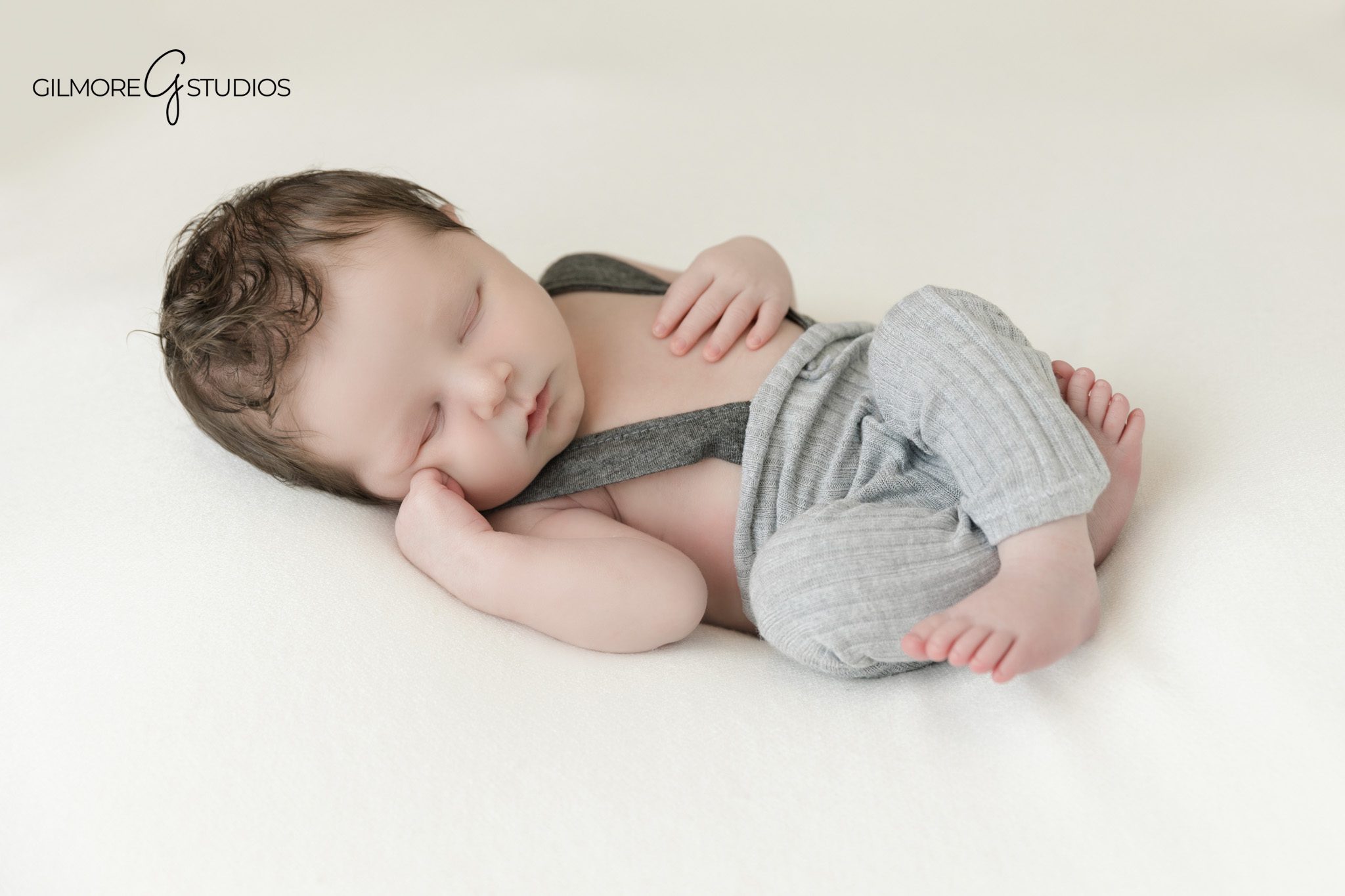 Newborn photography in Queen Creek with dad and baby connection
Wrapped newborn baby held by father in studio