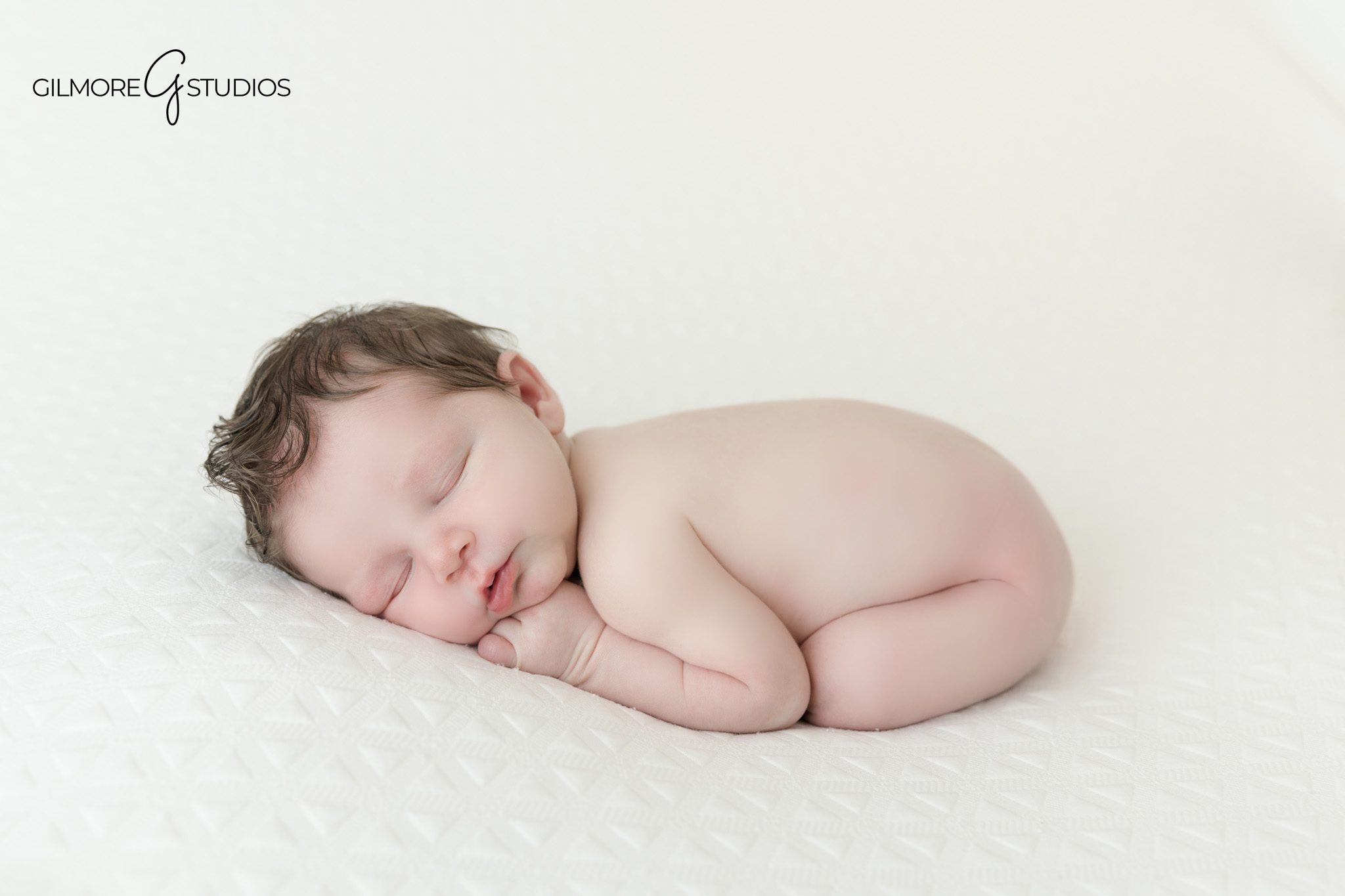 Overhead newborn portrait with baby and older sister
Newborn baby and toddler sibling lying on soft white blanket