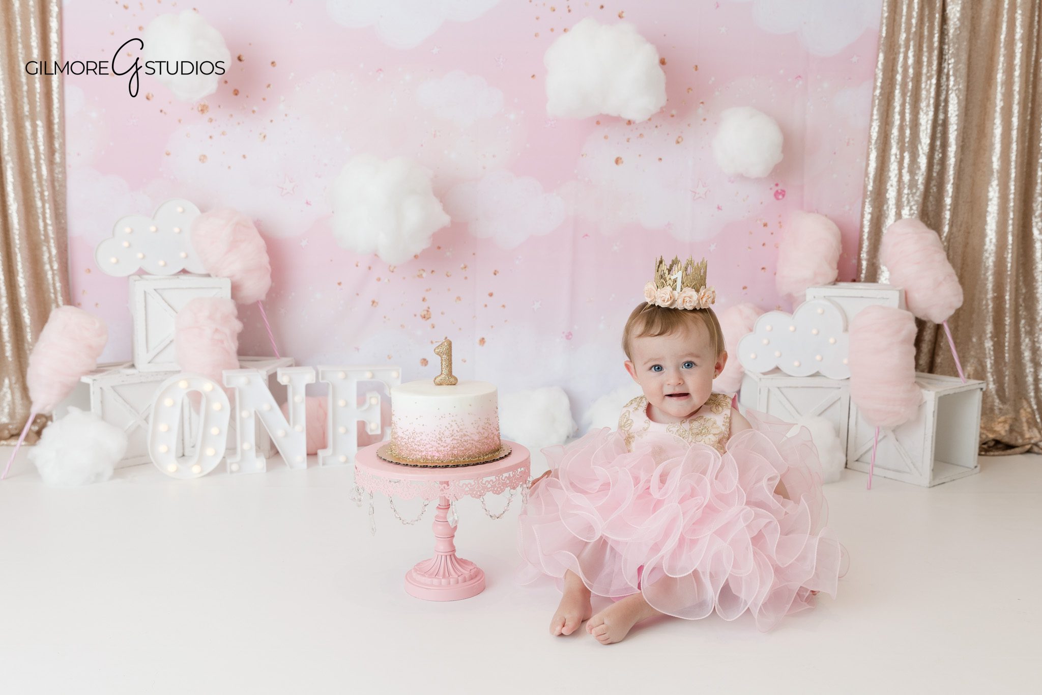 Newport Beach baby milestone photos with soft pink birthday theme
Baby girl sitting on white backdrop before cake smash session