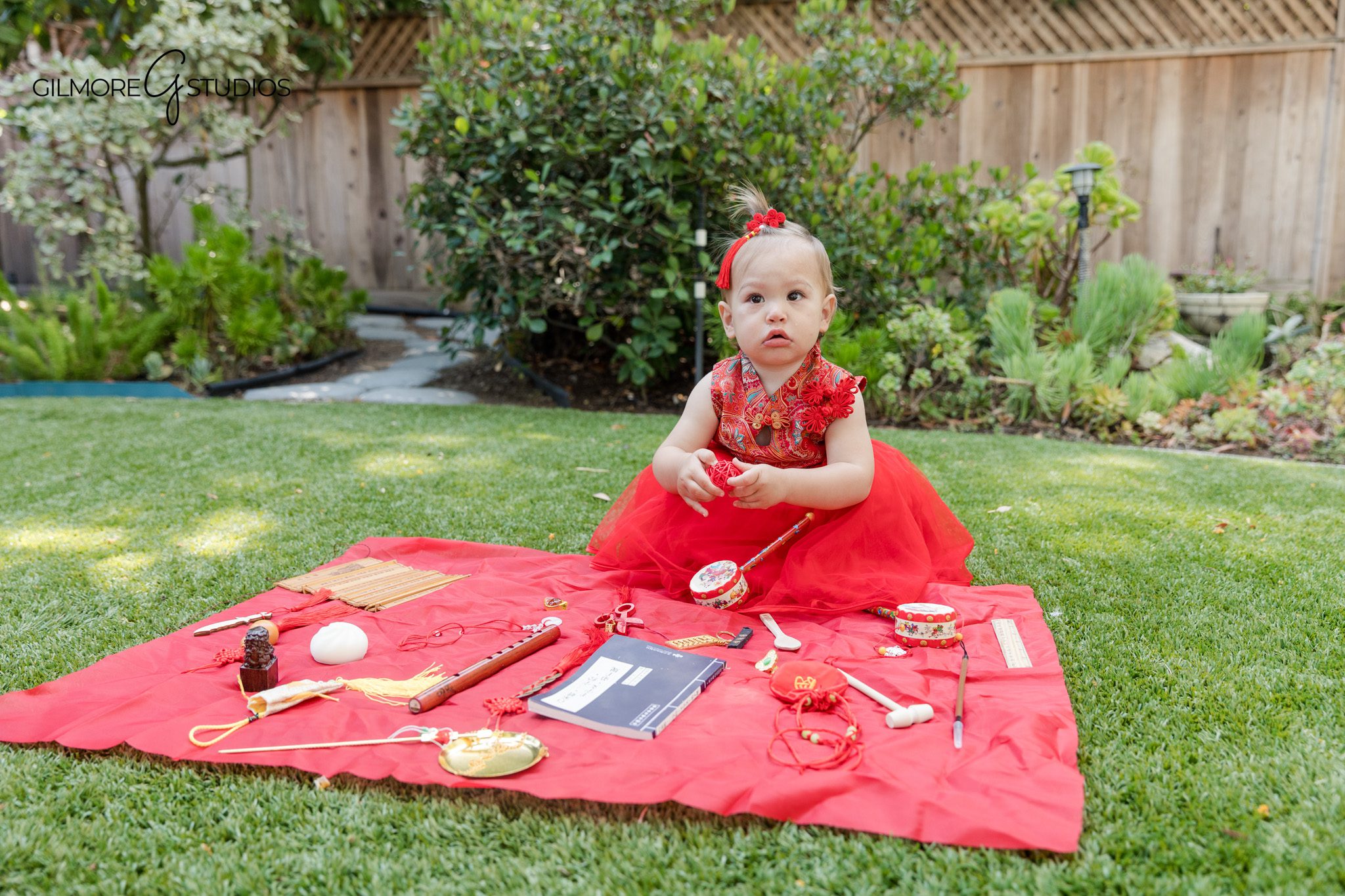 Queen Creek studio cake smash with soft feminine birthday decor
Baby girl eating cake during first birthday photo session
