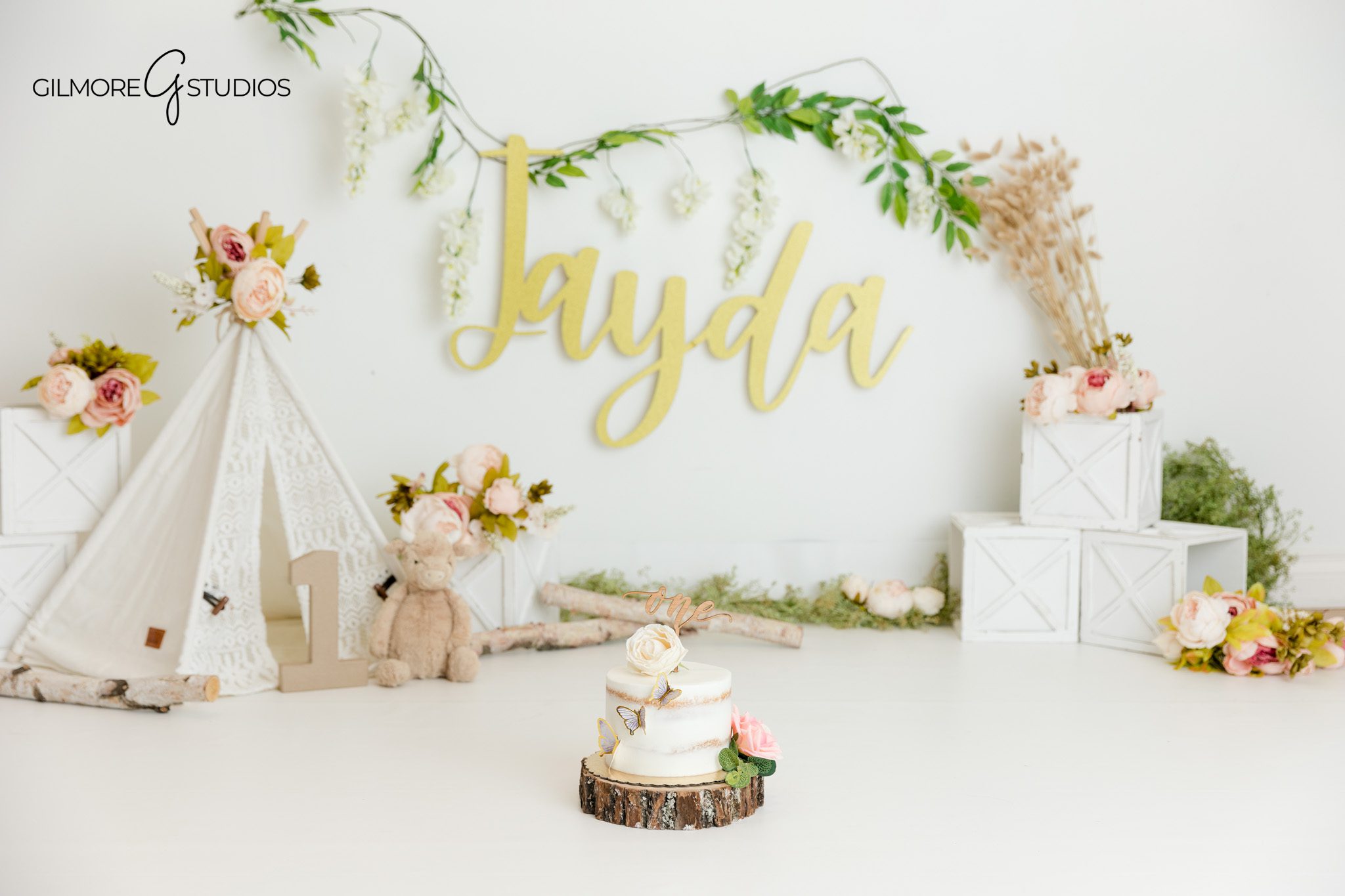 One year old cake smash session with soft flowers and gold name sign
Queen Creek AZ photographer capturing boho first birthday portraits