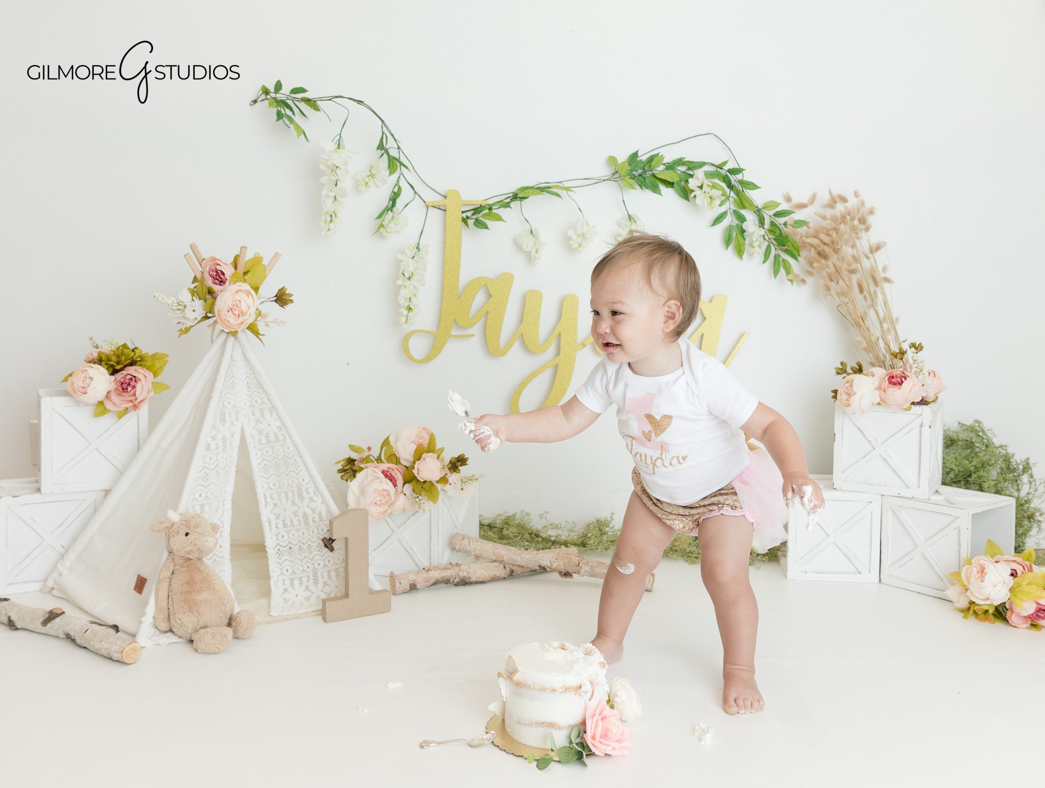 Baby girl with frosting on hands during cake smash photos
Queen Creek baby photographer capturing first birthday milestone