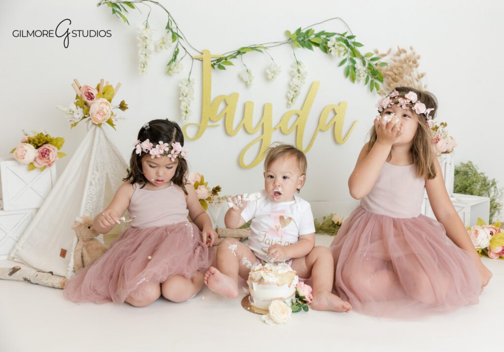Floral cake smash session with lace teepee and blush flowers
Baby girl holding frosting during Queen Creek cake smash session