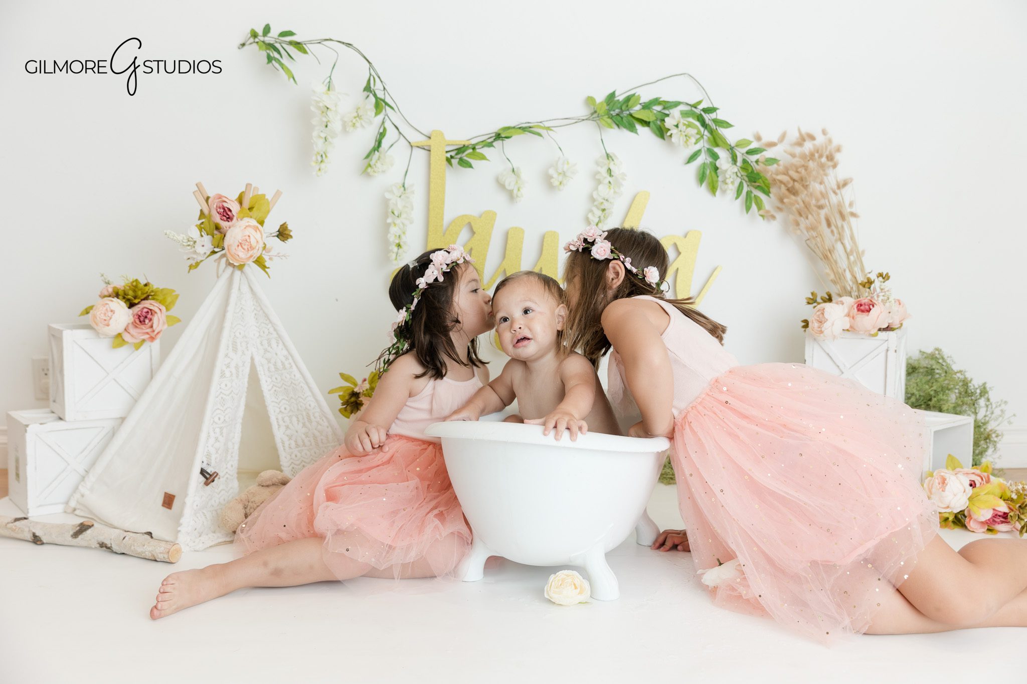 Queen Creek AZ first birthday photographer with floral studio setup
Boho cake smash portraits with white cake and pink floral accents