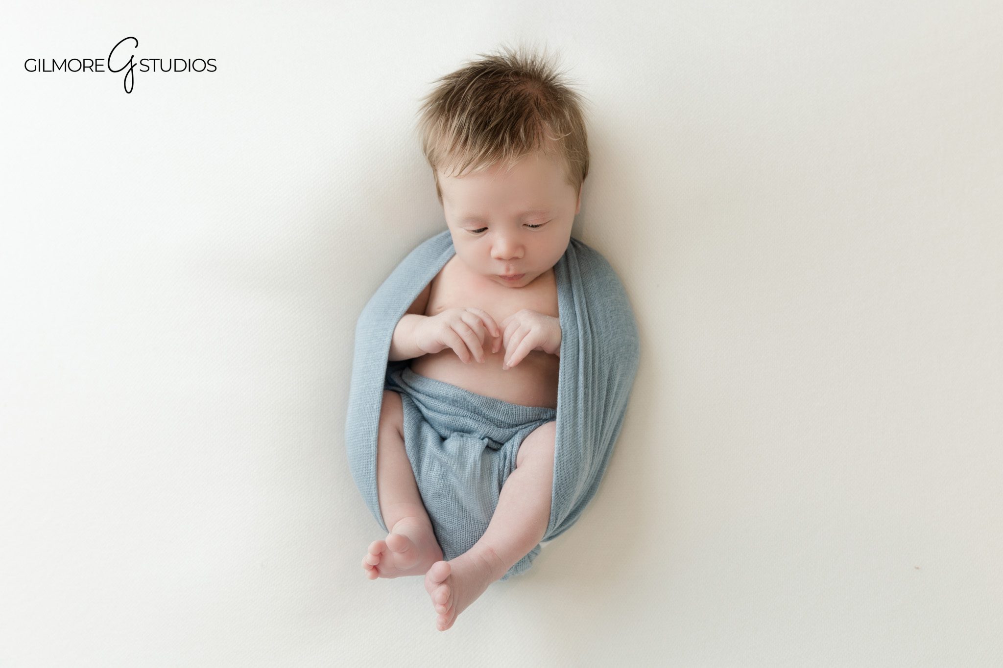 Studio newborn portrait of baby boy sleeping in white swaddle
Newborn baby boy wrapped in white for timeless Queen Creek portraits