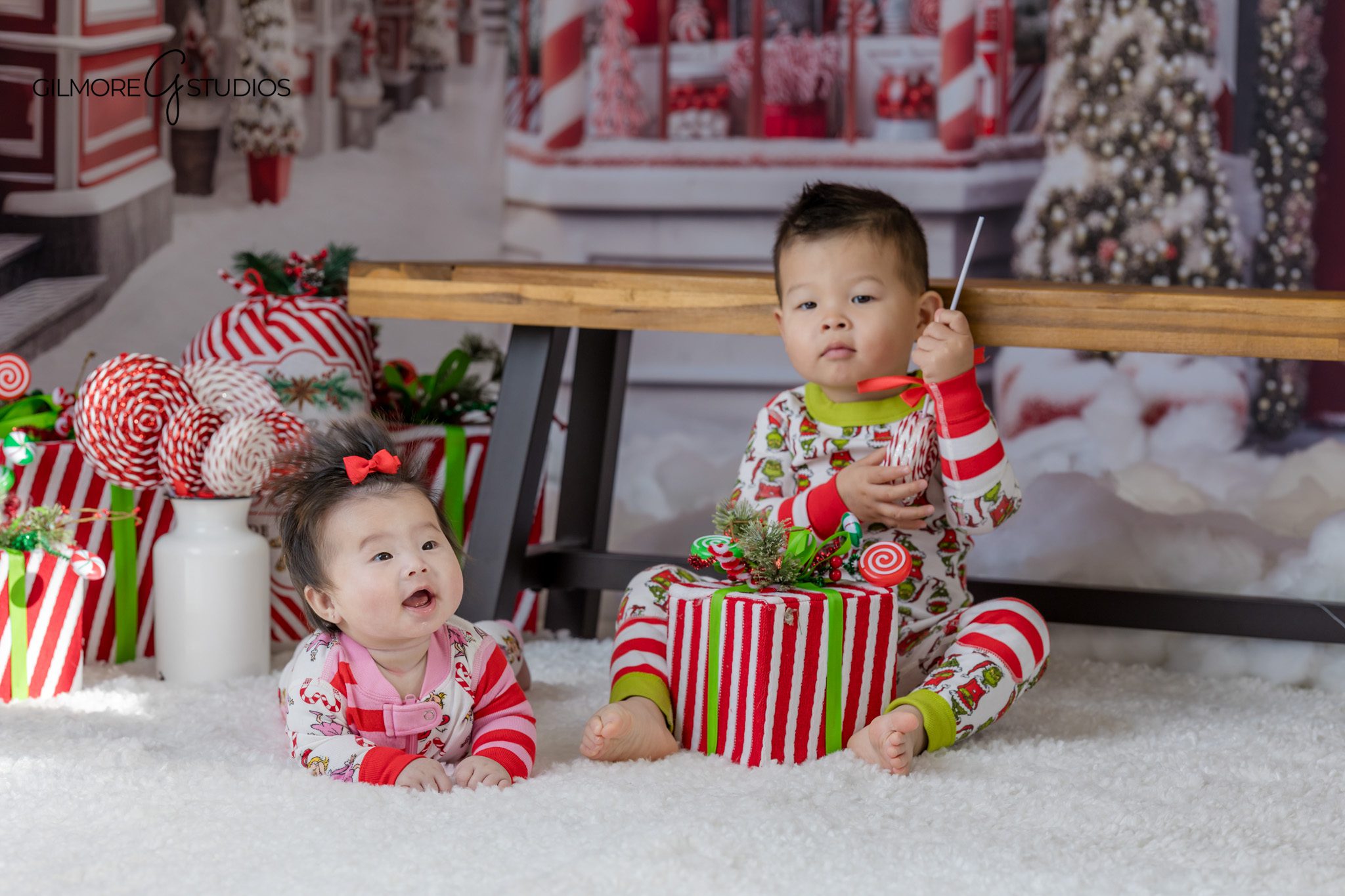 Queen Creek Santa mini session with family in green holiday outfits
Child sitting between parents while Santa reads a Christmas book