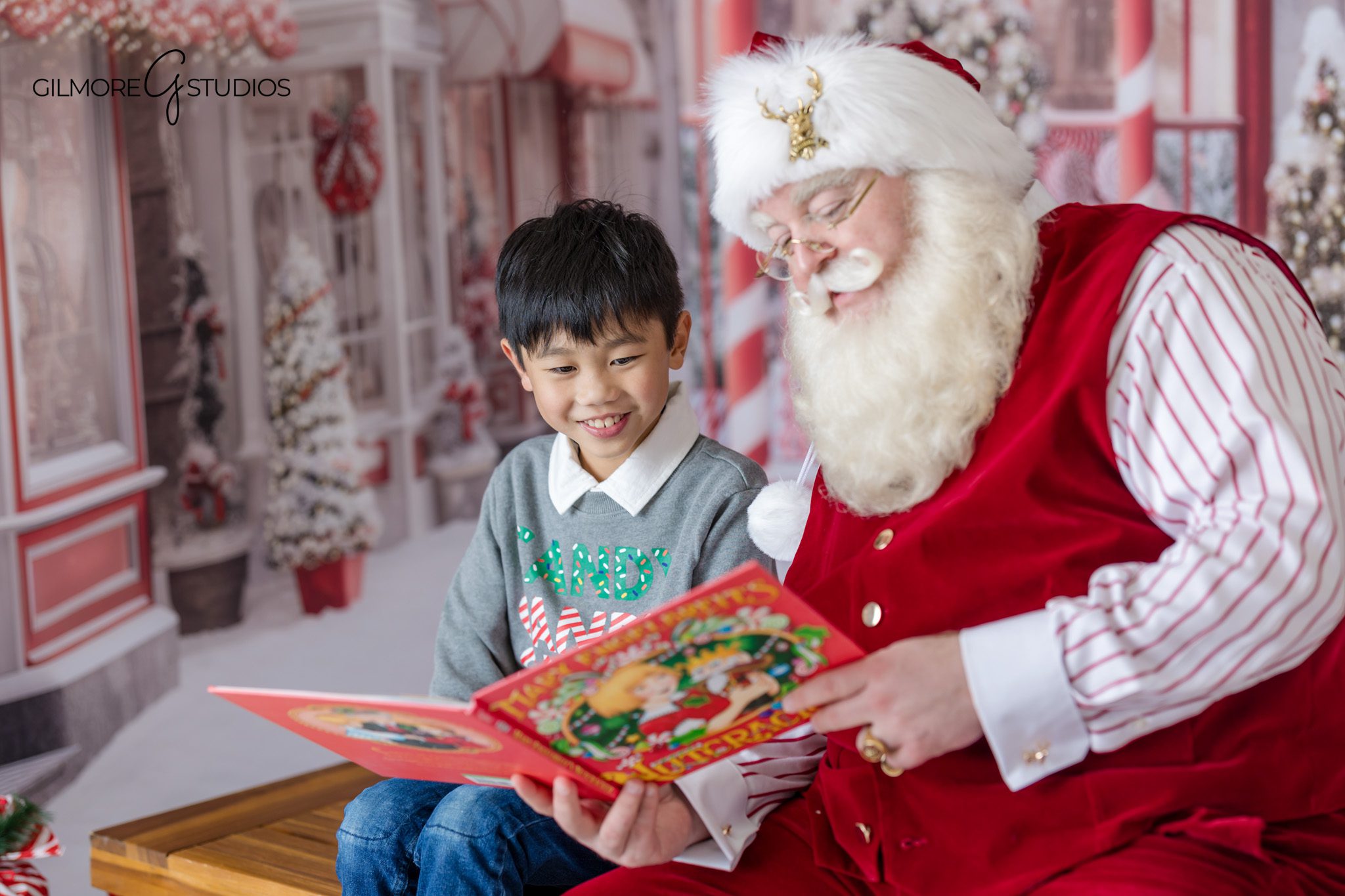 Christmas portrait with Santa and child by red present props
Santa checking nice list during Gilbert AZ Christmas photos