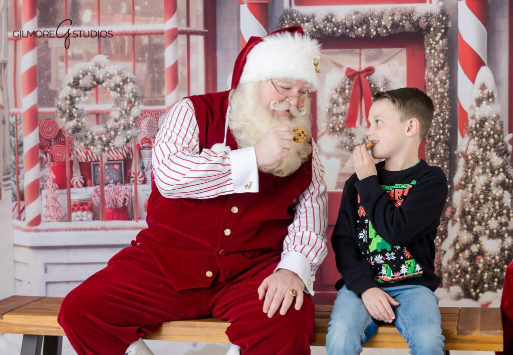 Queen Creek Christmas photos with Santa and sibling interaction
Santa sitting with boys on candy shop Christmas set