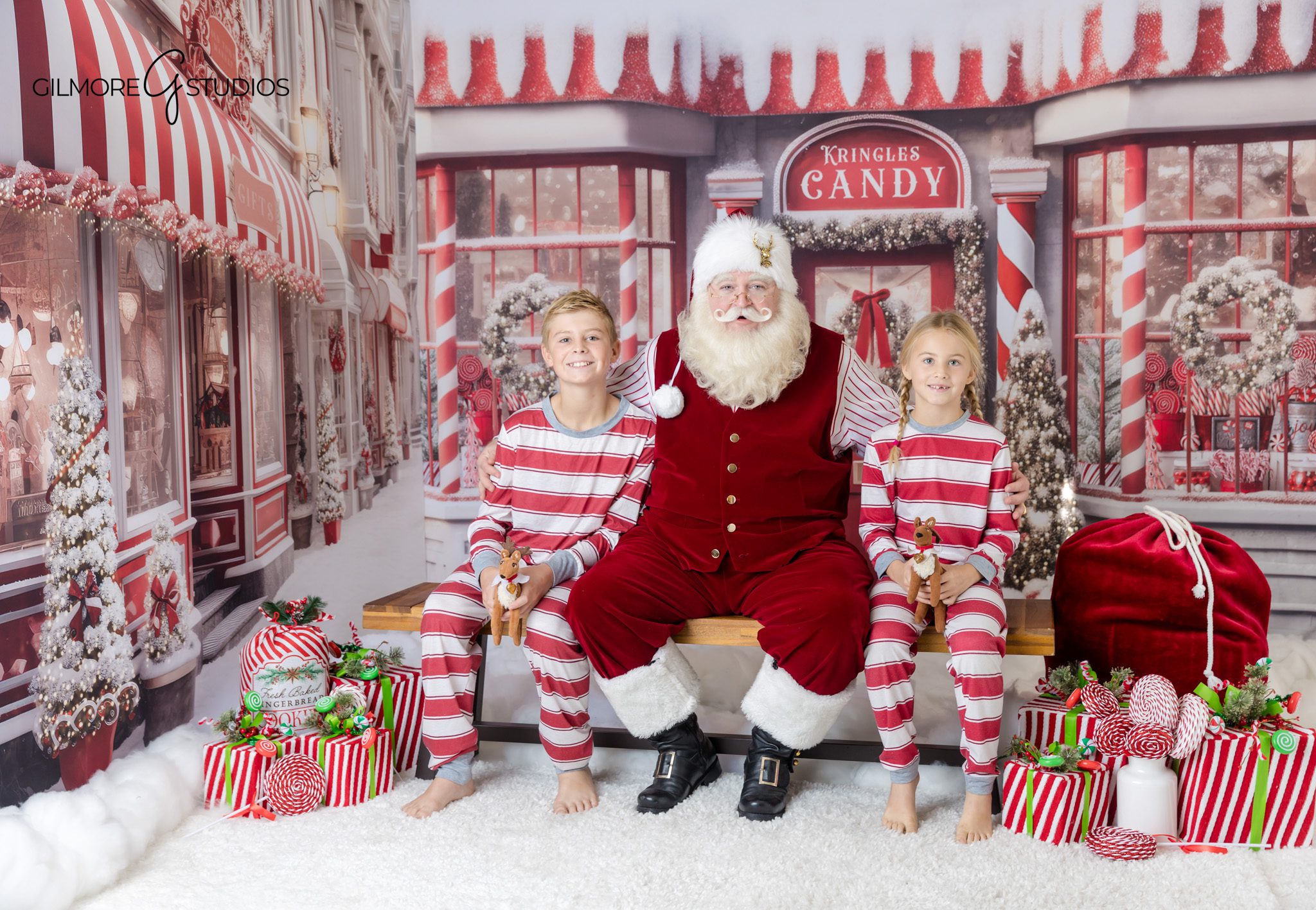 Child sitting between parents and Santa for holiday photos
Gilmore Studios Christmas photos with Santa and family