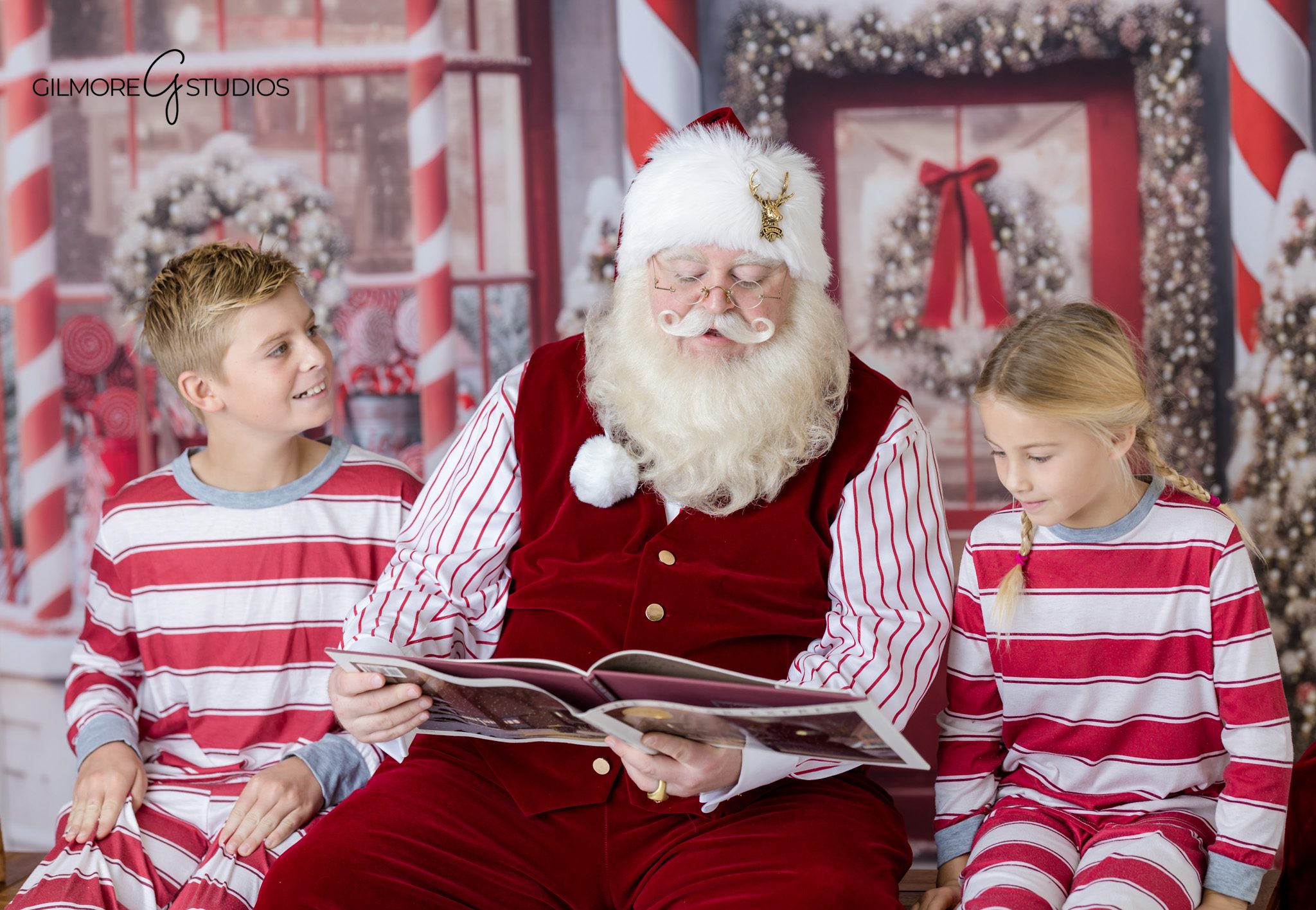 Santa photos near Gilbert AZ with child reading Christmas book
Gilbert AZ Santa photo session with candy shop Christmas backdrop