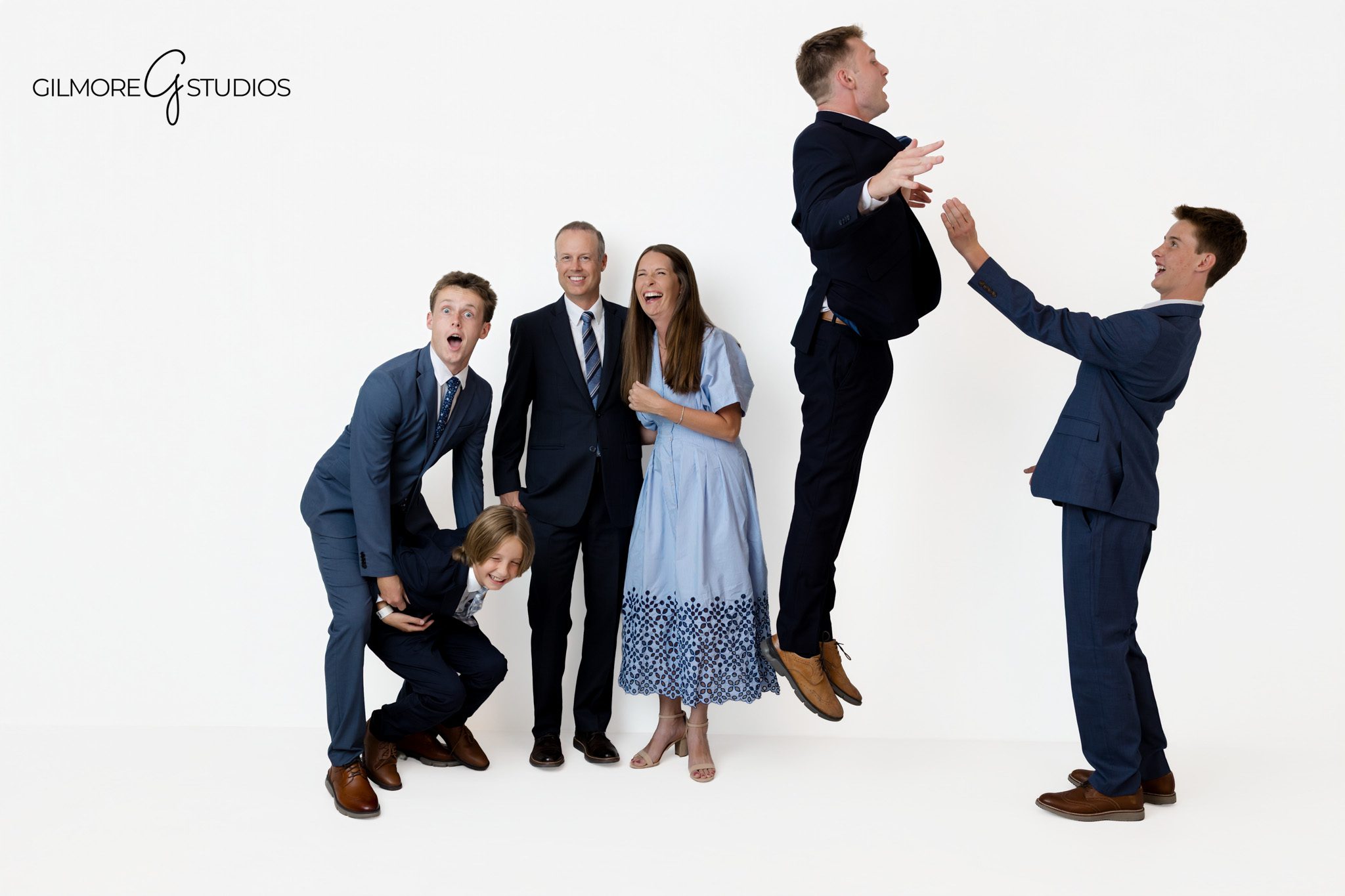 Queen Creek family photography with coordinated blue and navy outfits
Modern studio family portrait on a bright white background