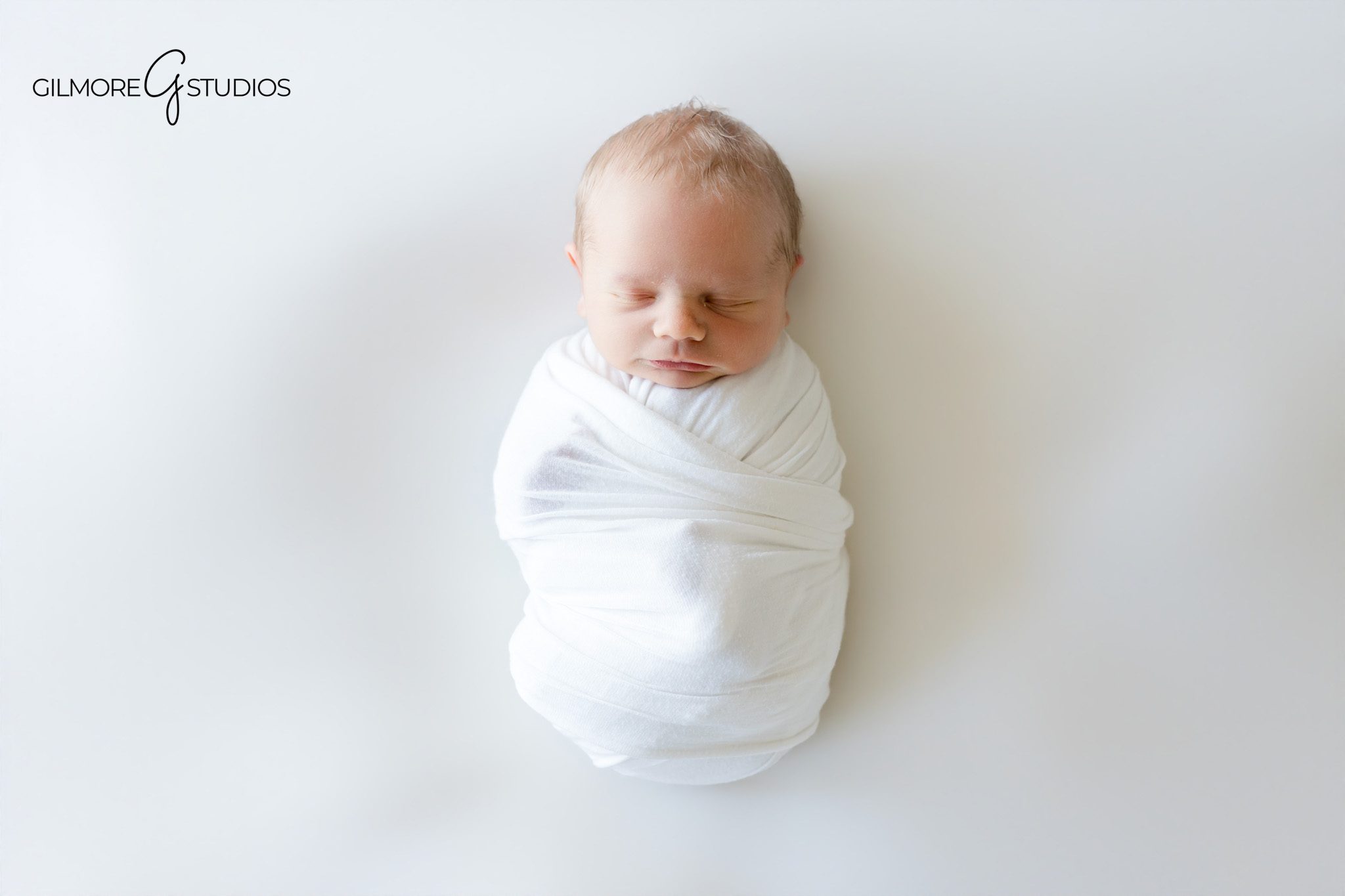 Father holding newborn baby during Newport Beach home session
Dad smiling at newborn baby wrapped in white