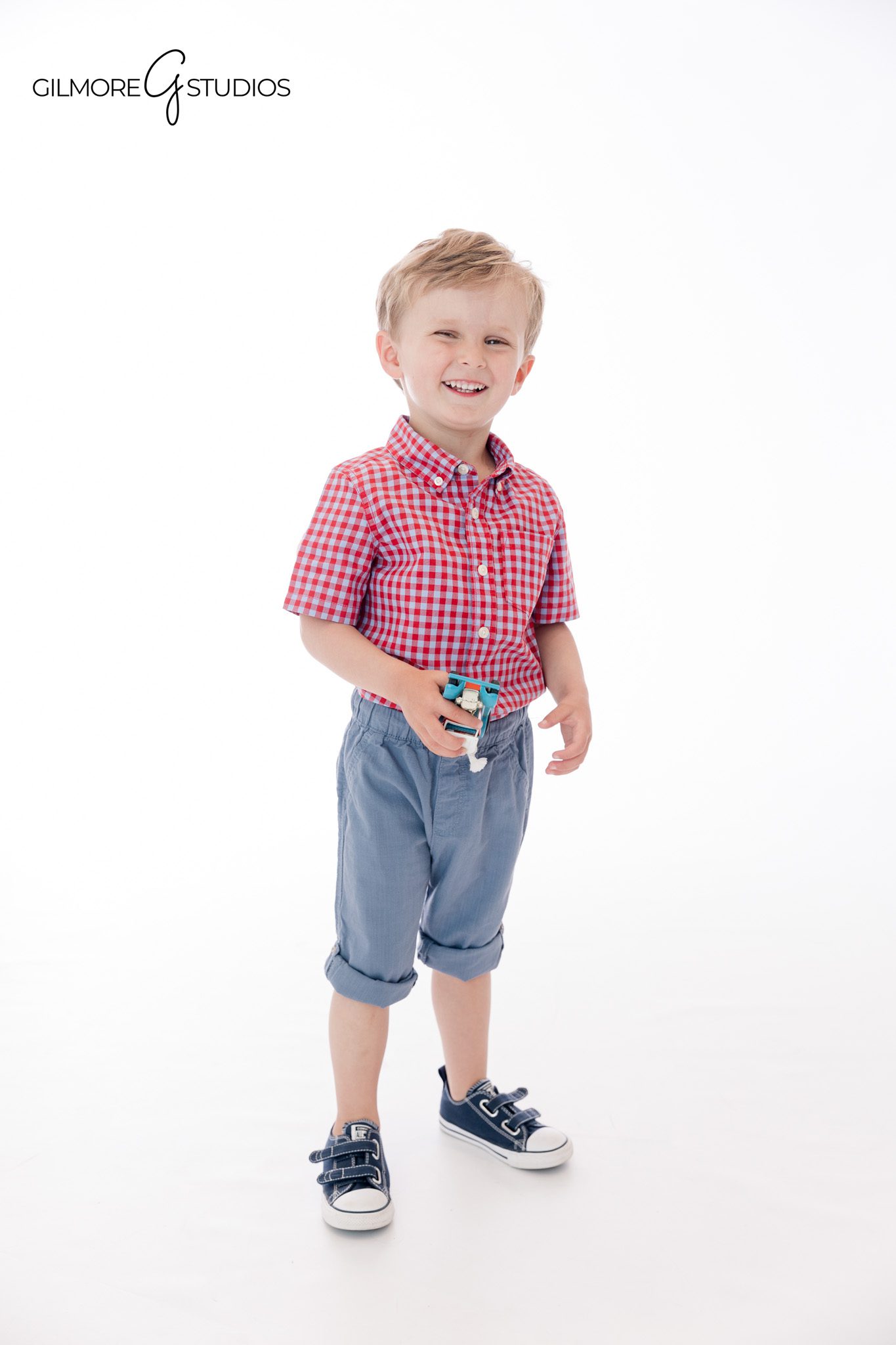 Child smiling in navy sweater during Gilbert AZ portrait session
Personality portrait of young boy sitting cross legged