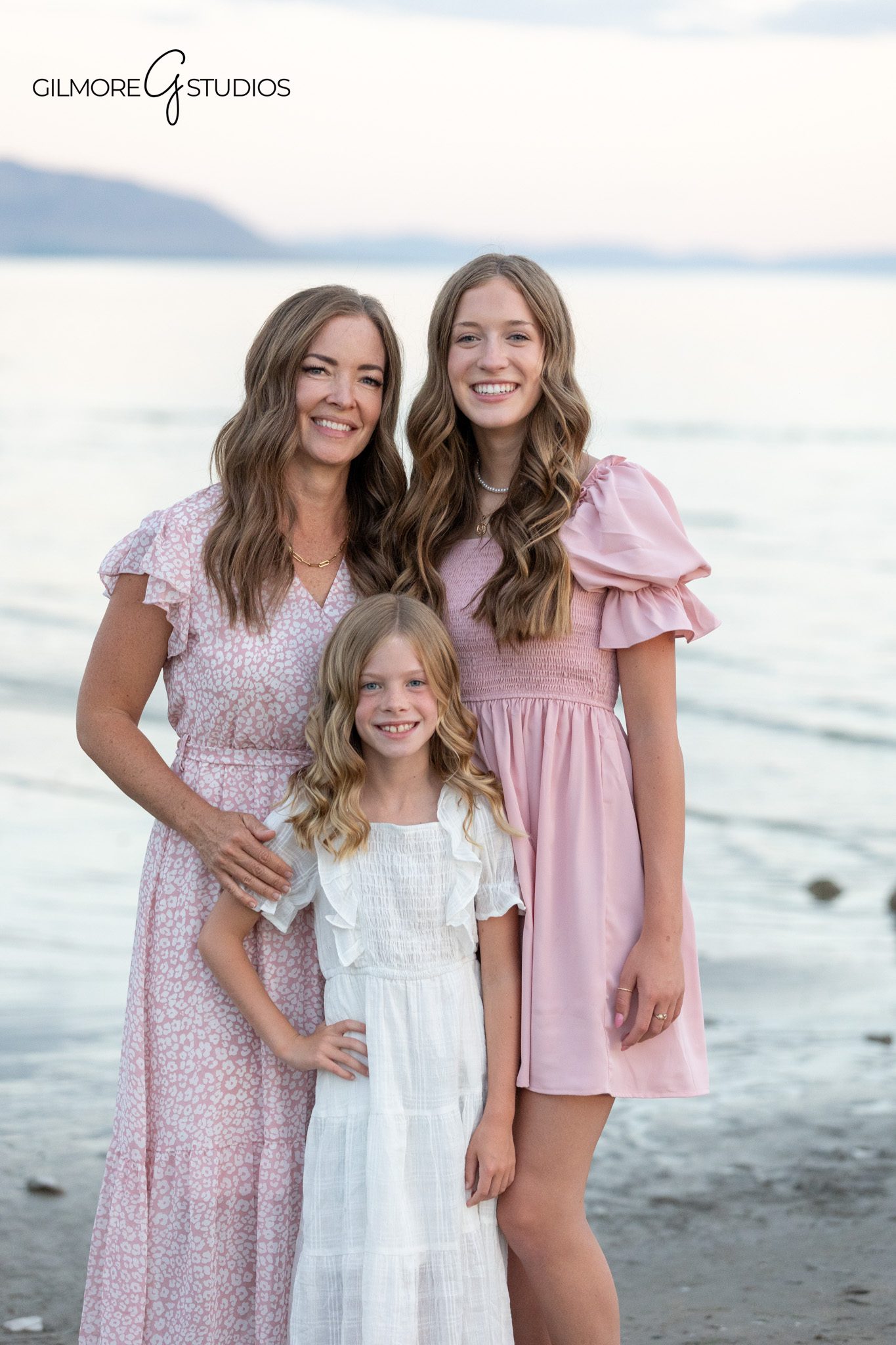 Large family portrait with soft pastel outfits and mountain background
Destination family photos in Utah with peaceful lake scenery