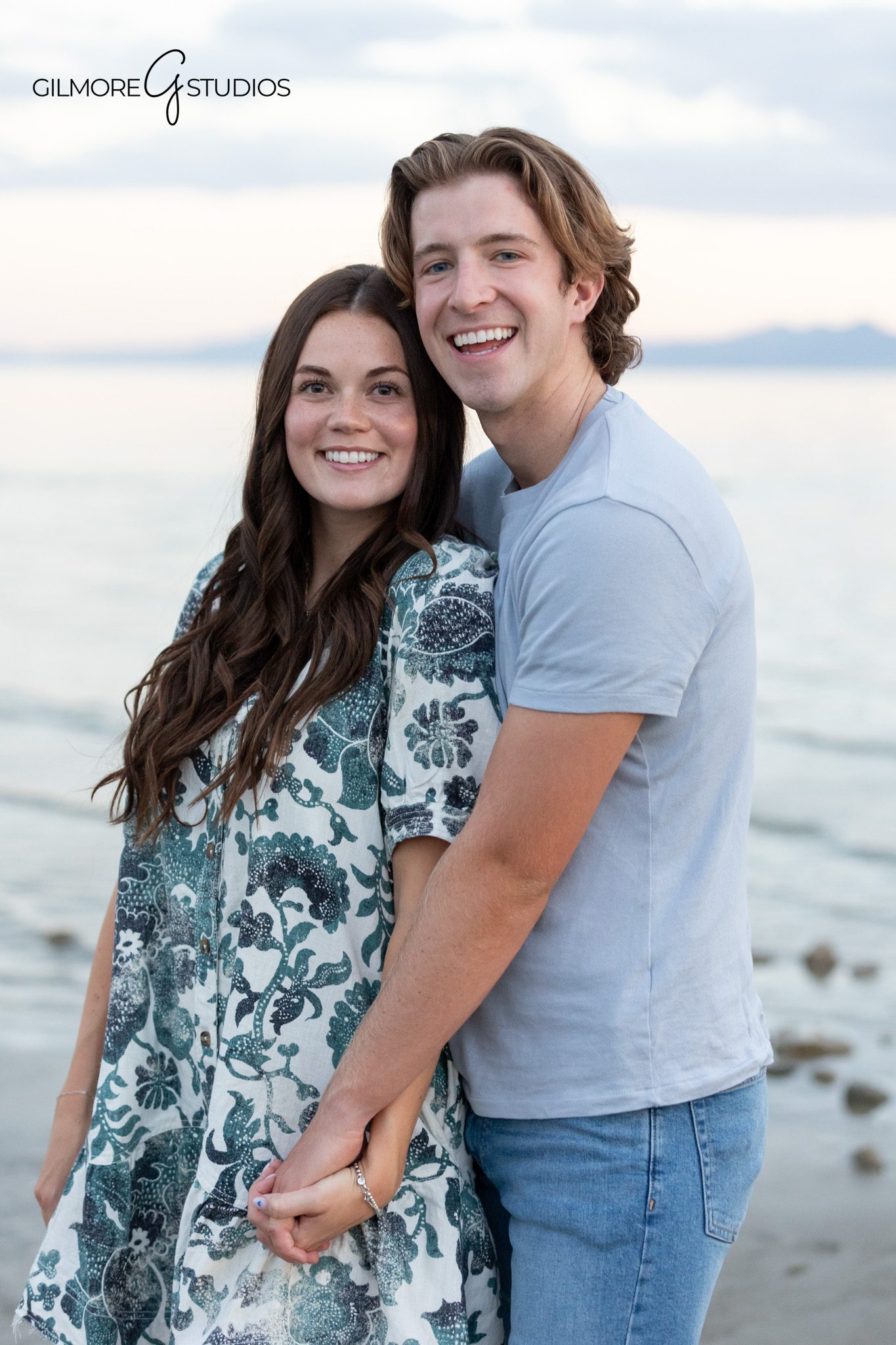 Family holding small dog during lakeside family portraits
Utah family photography with mountains, water, and family dog
