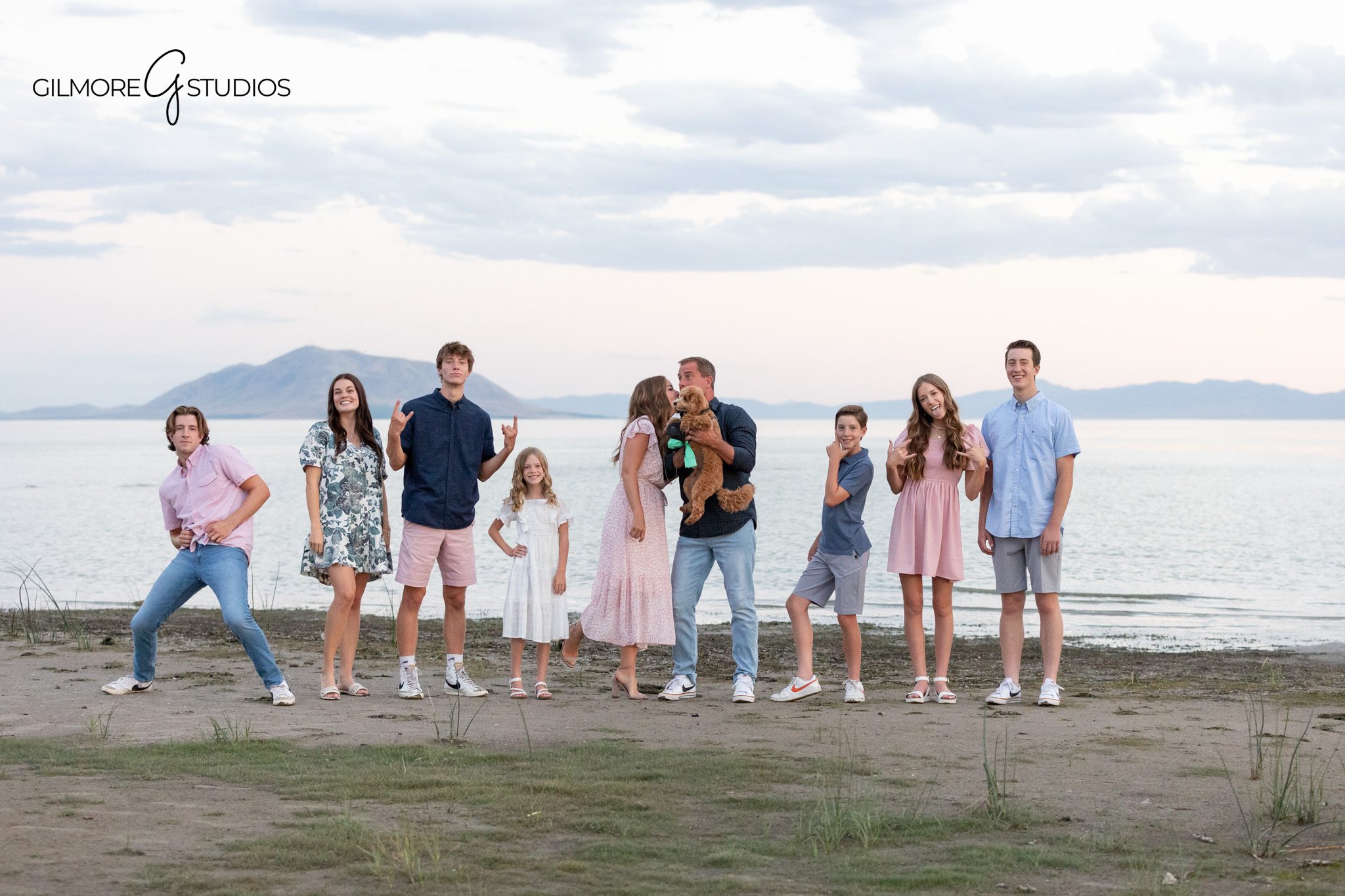 Family portrait with parents and seven children by the lake
Lakeside family photos with pastel clothing and mountain background