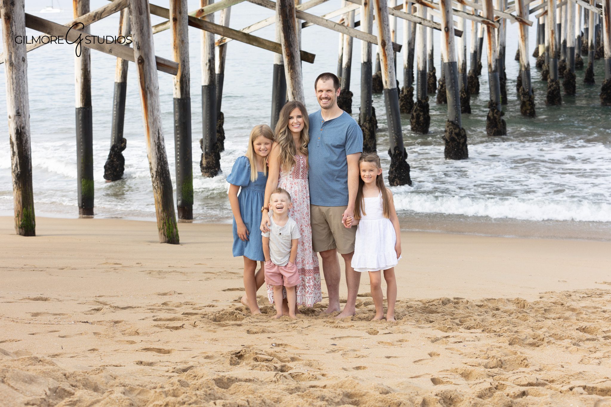 Newport Beach Pier family portrait with pink and blue wardrobe
Parents and children standing on the sand at Newport Beach Pier