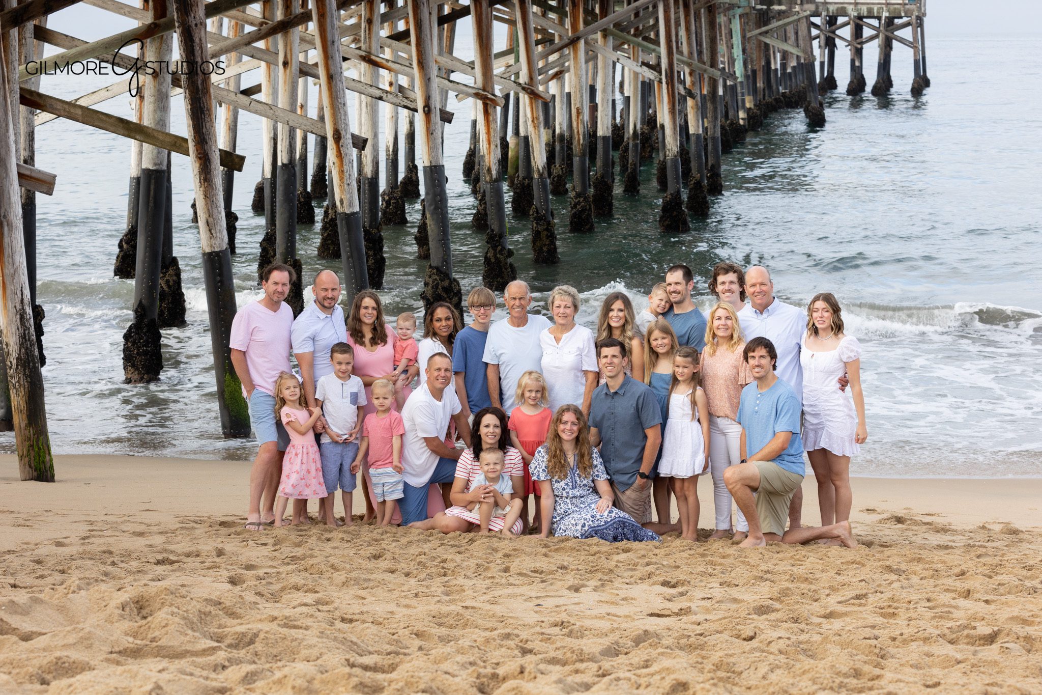 Family reunion portrait with soft beach colors and ocean views
Extended family beach session with coordinated pink, blue, and white outfits