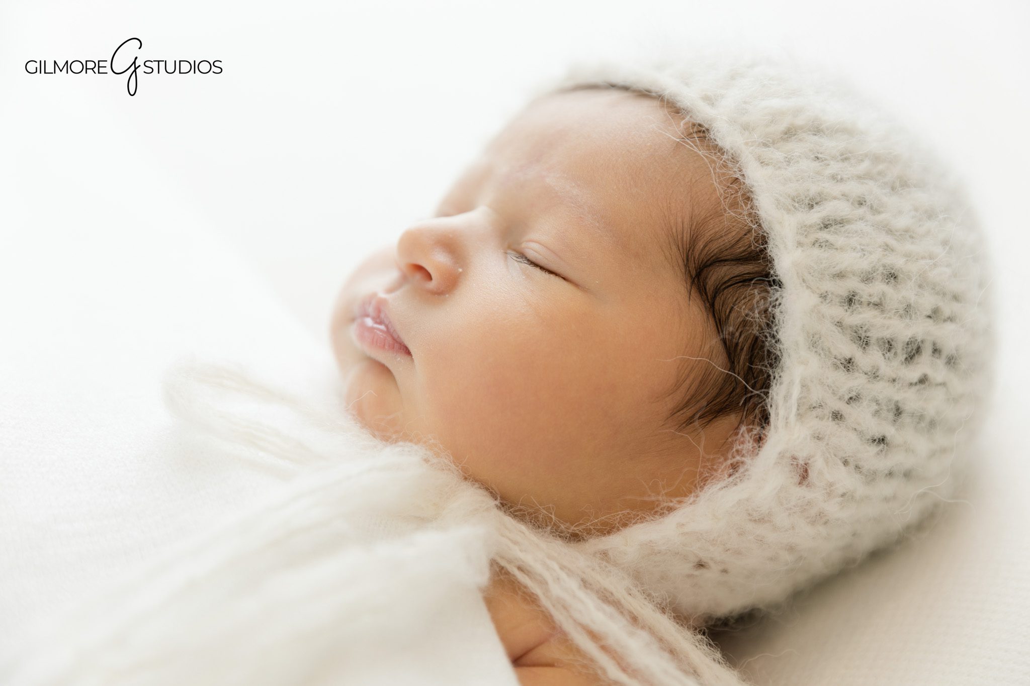 Newborn detail photo with soft eyelashes and tiny lips
Baby girl wrapped in white for timeless newborn photos
