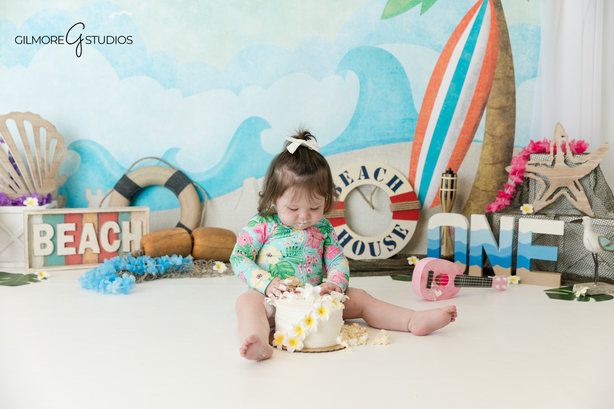 Baby girl reaching for cake during Queen Creek cake smash session
Cake smash session with beach backdrop and coastal birthday decor