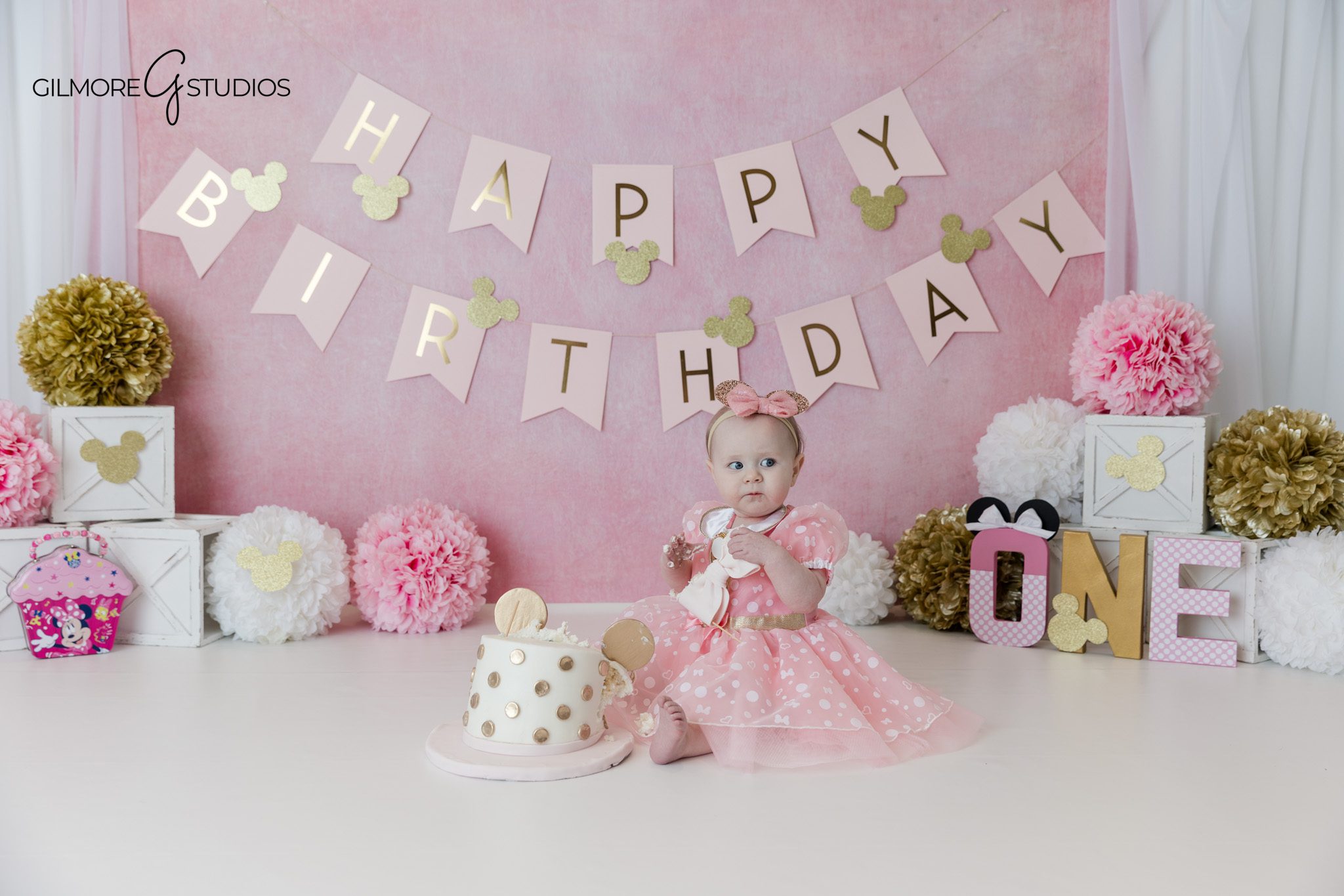 Baby girl reaching for cake during Queen Creek cake smash session
Pink Minnie Mouse birthday session with cake and banner