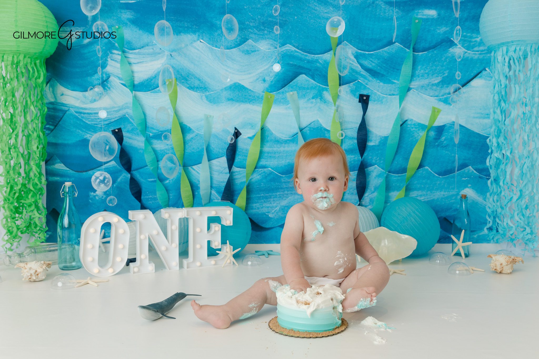 Baby boy laughing during under the sea first birthday session
Blue and aqua cake smash theme for baby boy first birthday