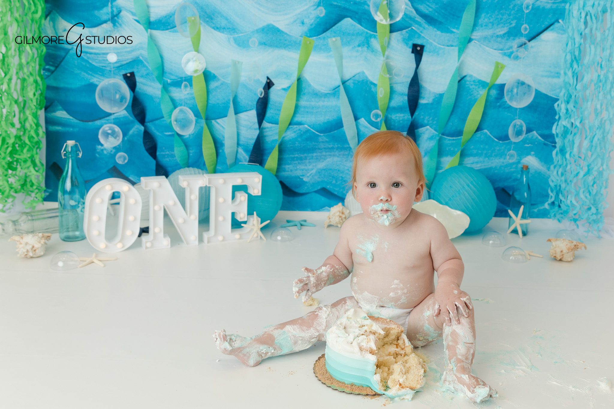 Baby boy first birthday photos with silver number one balloon
Simple studio milestone portrait before under the sea cake smash