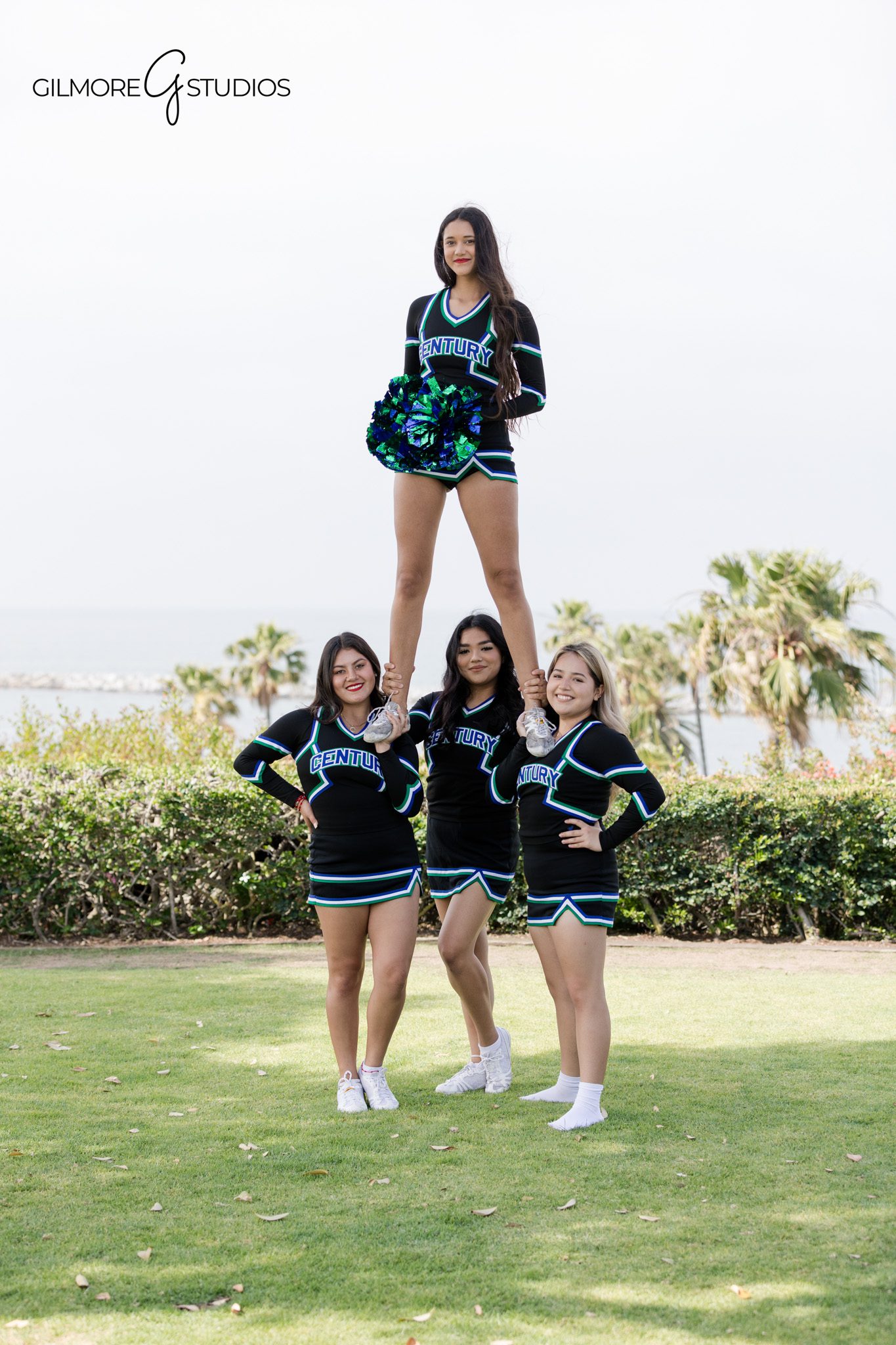 Century High School cheer portraits with blue and green pom poms
Individual cheerleader portrait in uniform by the water in Newport Beach