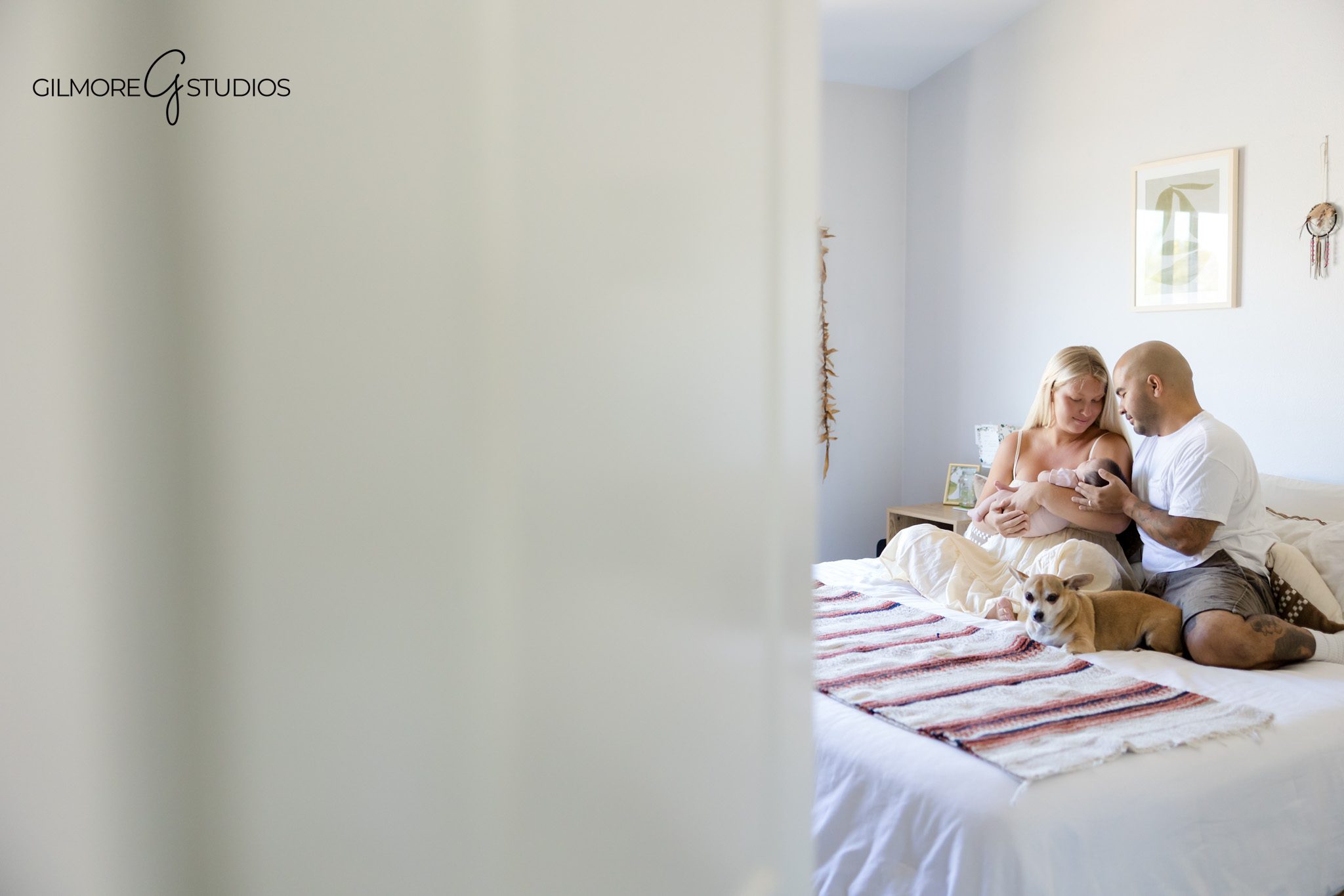 Sweet newborn moment with mom cuddling baby in neutral bedroom
Lifestyle newborn portrait of baby girl in mother’s arms