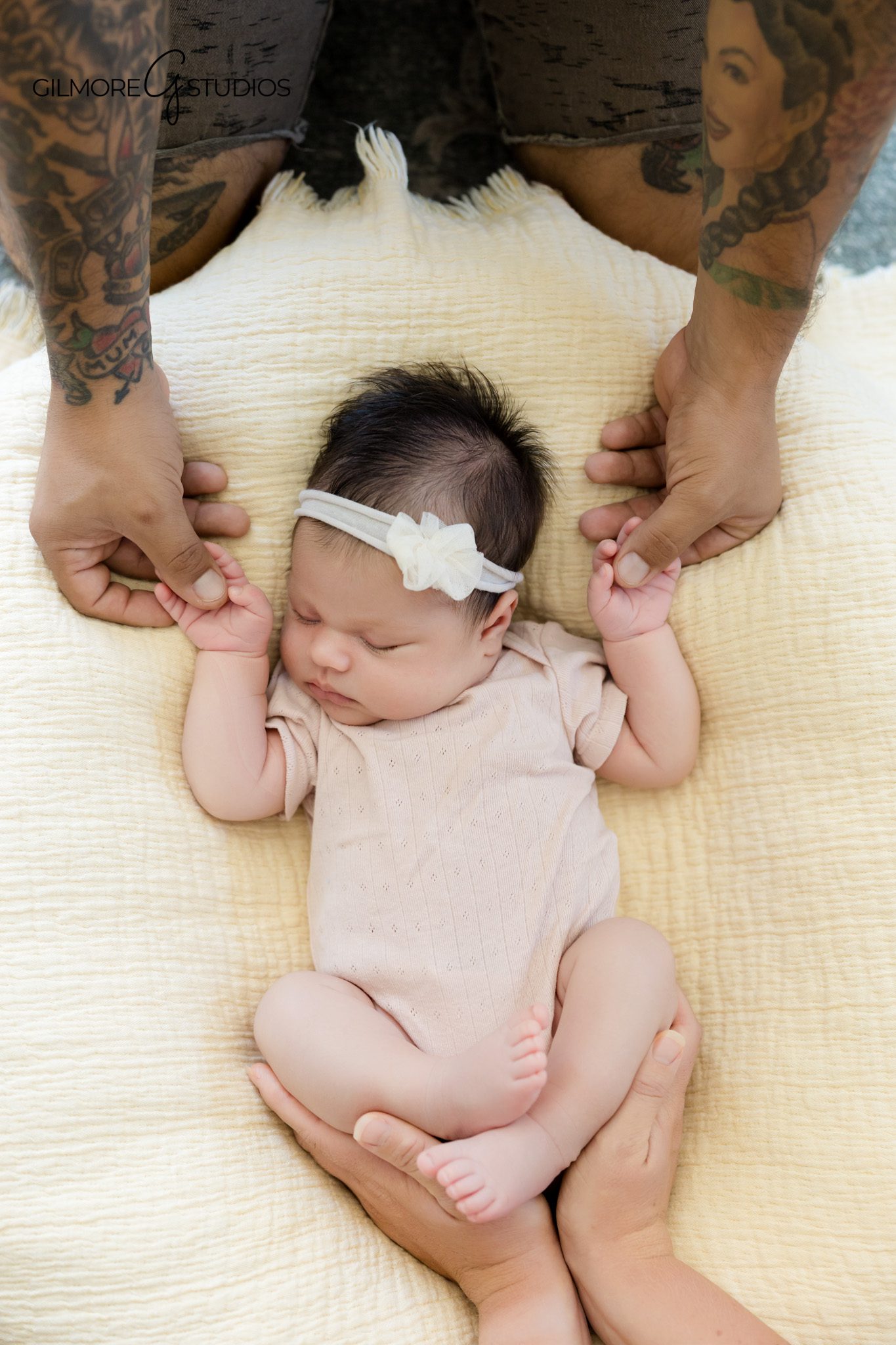 Baby girl wrapped in white swaddle with soft bow headband
Simple newborn portrait in white swaddle on neutral bedding