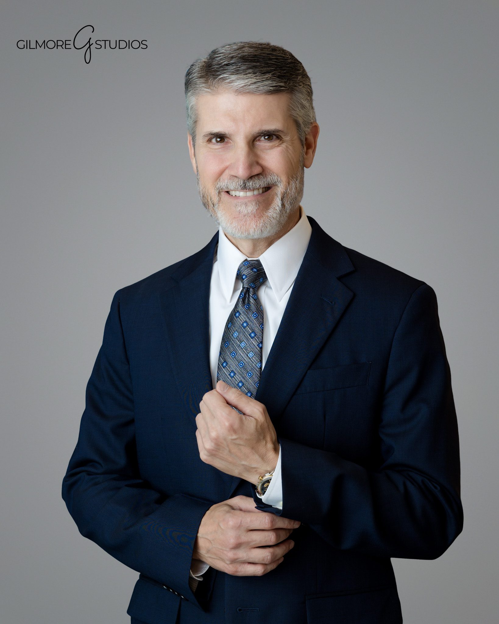 Modern corporate headshot with neutral gray background
Professional headshot session with suit jacket and open collar