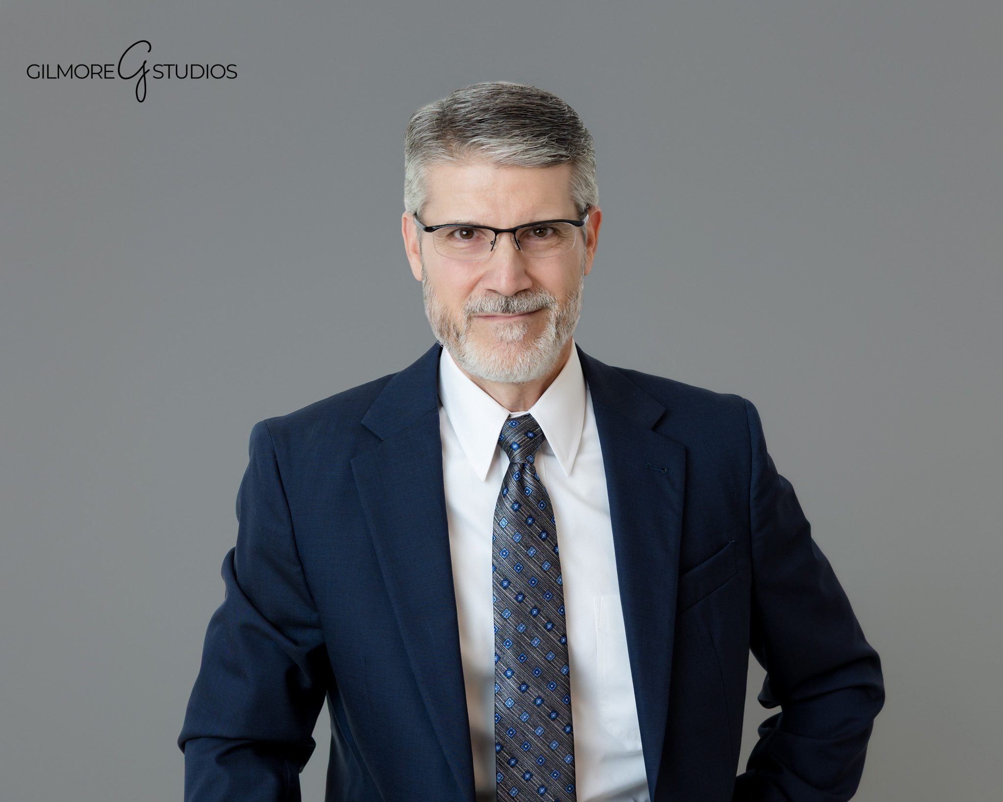 Queen Creek AZ individual headshot photographer with professional gray studio backdrop
Professional headshot of man in navy suit on gray backdrop